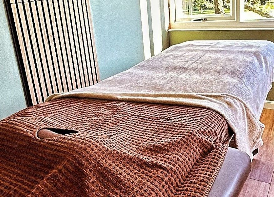 Cozy massage table at The Cabin, Cossall, England, GB, bathed in natural light.