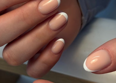 French manicure at Irysha.beauty, Chichester, England, GB. Nude nails with white tips in close-up view.
