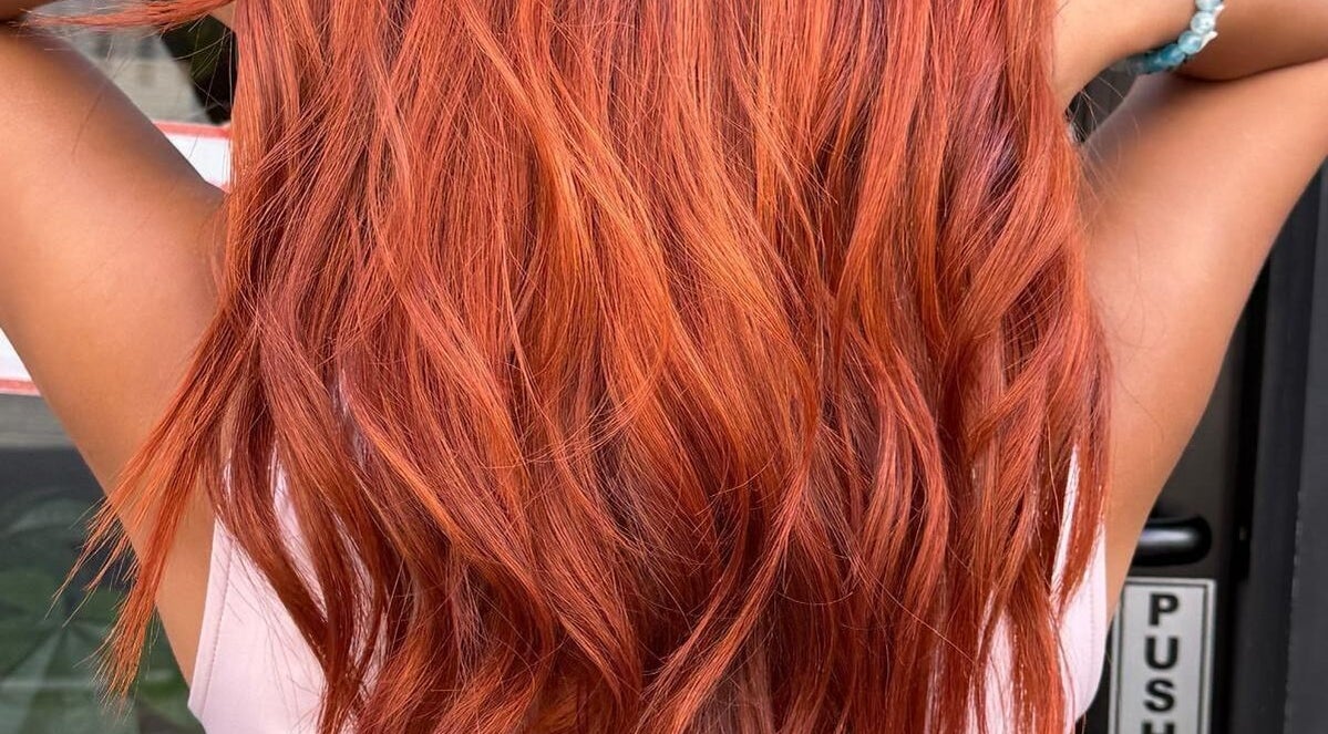 Vibrant red hair styled in waves at BrighTouch, New York, New York, US, showcasing expert coloring.