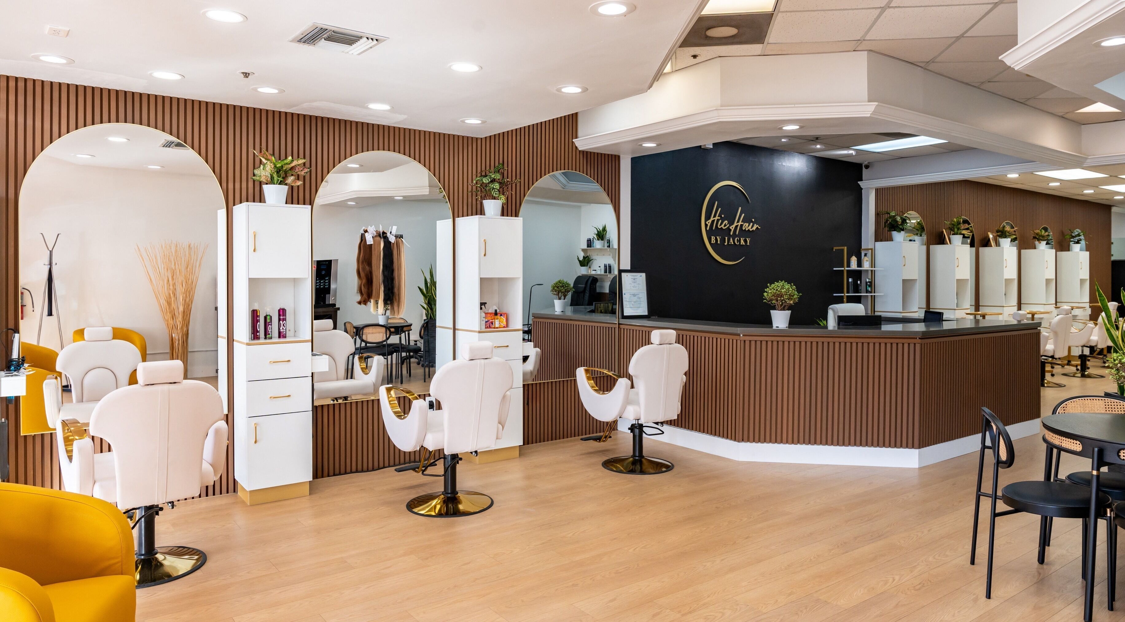 Interior moderno de Chic Hair by Jacky en Doral, Florida, US, mostrando sillas blancas y mostrador elegante.
