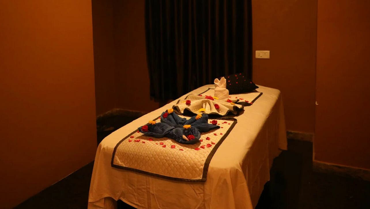 Luxurious massage table at Dhara Spa - HSR Layout, Bengaluru, Karnataka, IN with elegant towel decor.