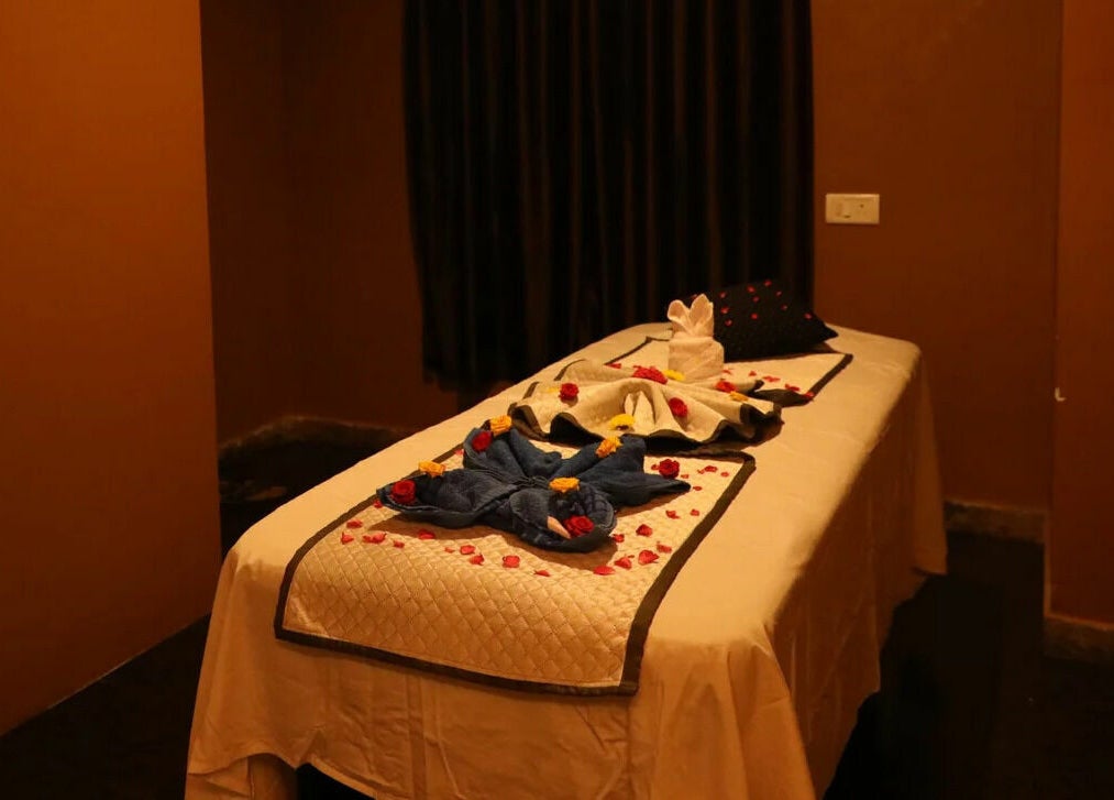 Luxurious massage table at Dhara Spa - HSR Layout, Bengaluru, Karnataka, IN with elegant towel decor.