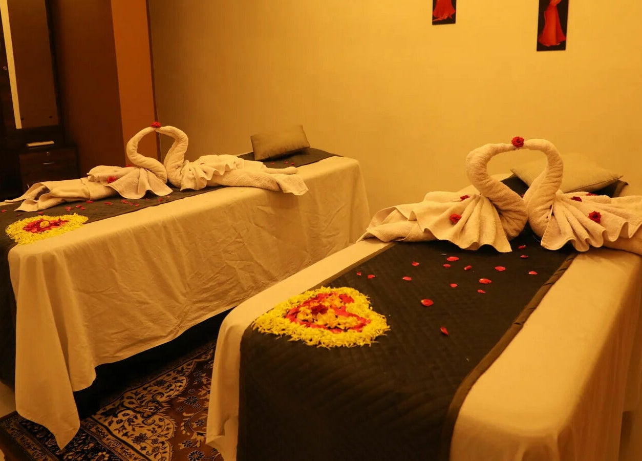 Elegant massage room at Dhara Spa - HSR Layout, Bengaluru, Karnataka, IN with swan towel art and rose petals.