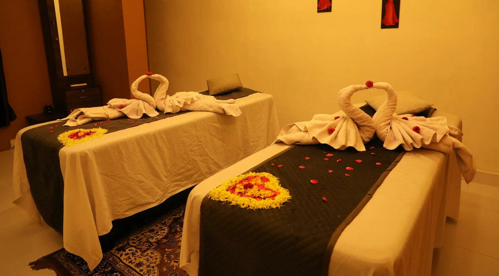Elegant massage room at Dhara Spa - HSR Layout, Bengaluru, Karnataka, IN with swan towel art and rose petals.
