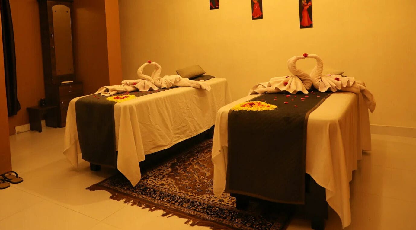 Elegant massage room at Dhara Spa - HSR Layout in Bengaluru, Karnataka, IN with two decorated tables.