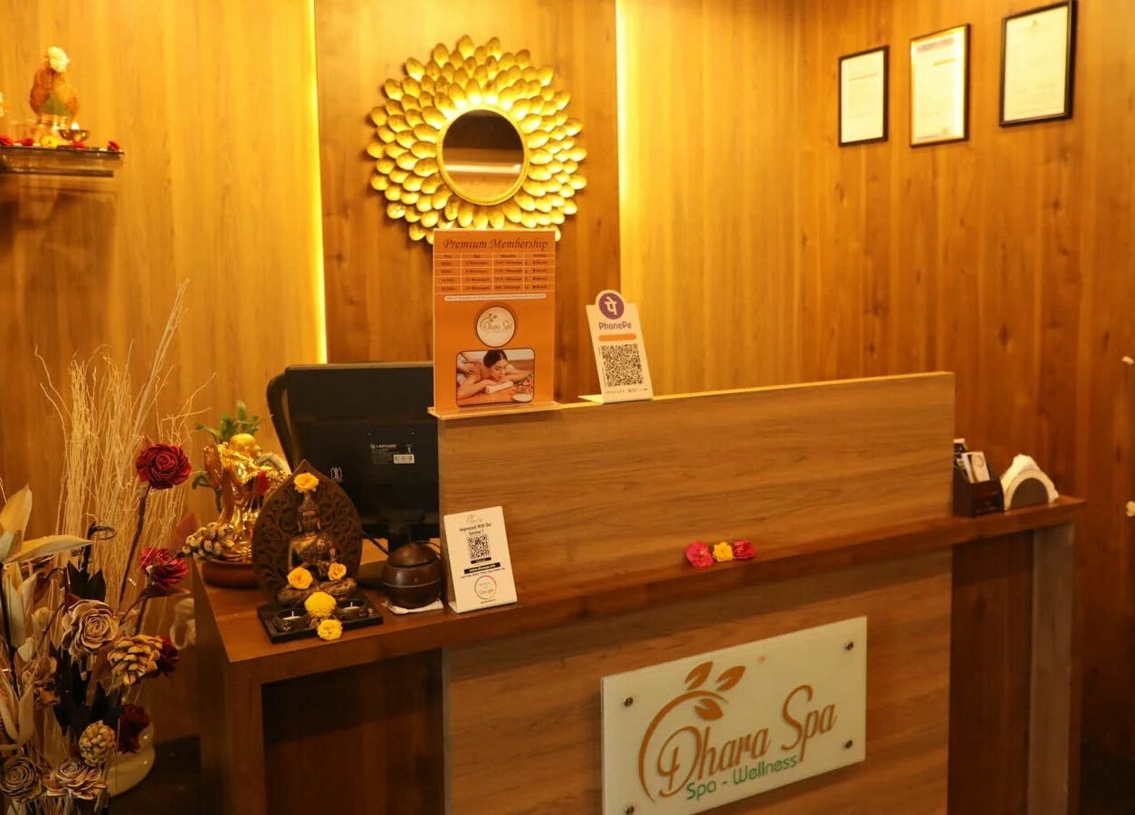 Welcoming reception at Dhara Spa - HSR Layout, Bengaluru, Karnataka, IN with elegant wood decor and warm lighting.