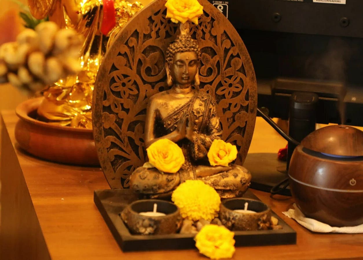 Tranquil Buddha statue with yellow flowers at Dhara Spa - HSR Layout, Bengaluru, Karnataka, IN.