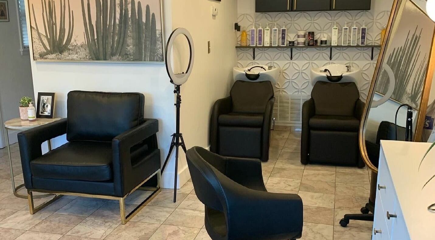Modern salon interior at Gold Dust Studio in Lakewood, Ohio, US with stylish black chairs and sleek decor.