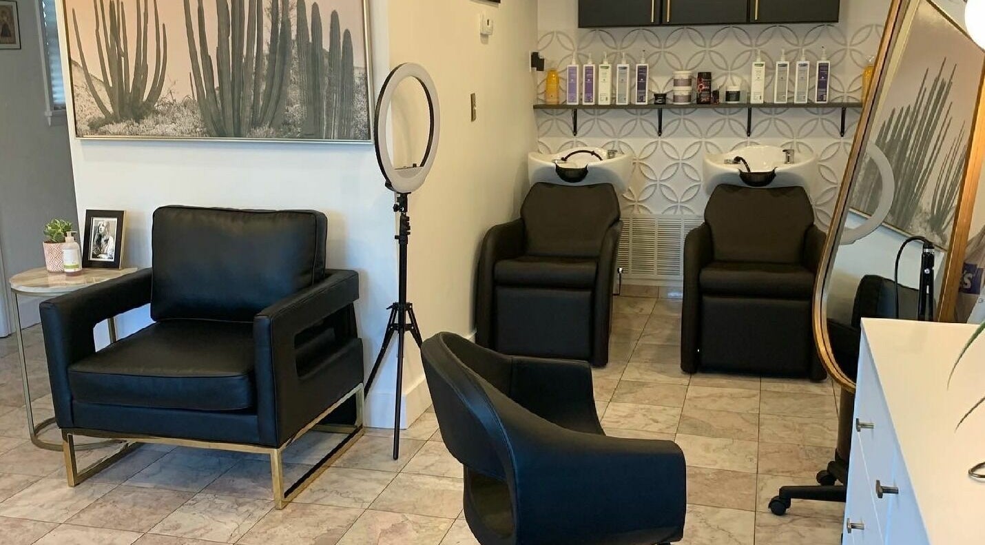 Modern salon interior at Gold Dust Studio in Lakewood, Ohio, US with stylish black chairs and sleek decor.