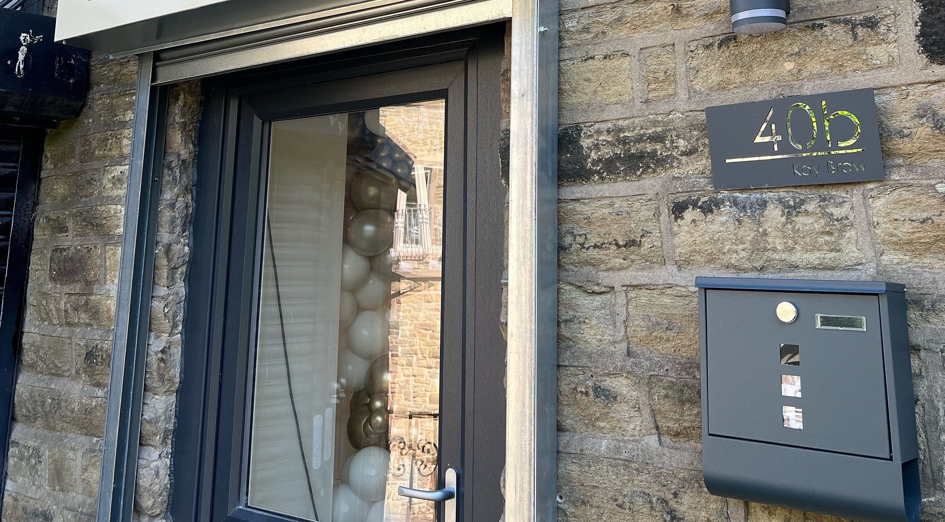 Chic entrance of Heavenly Beauty at 40b Ramsbottom, England, GB with modern window and signage.
