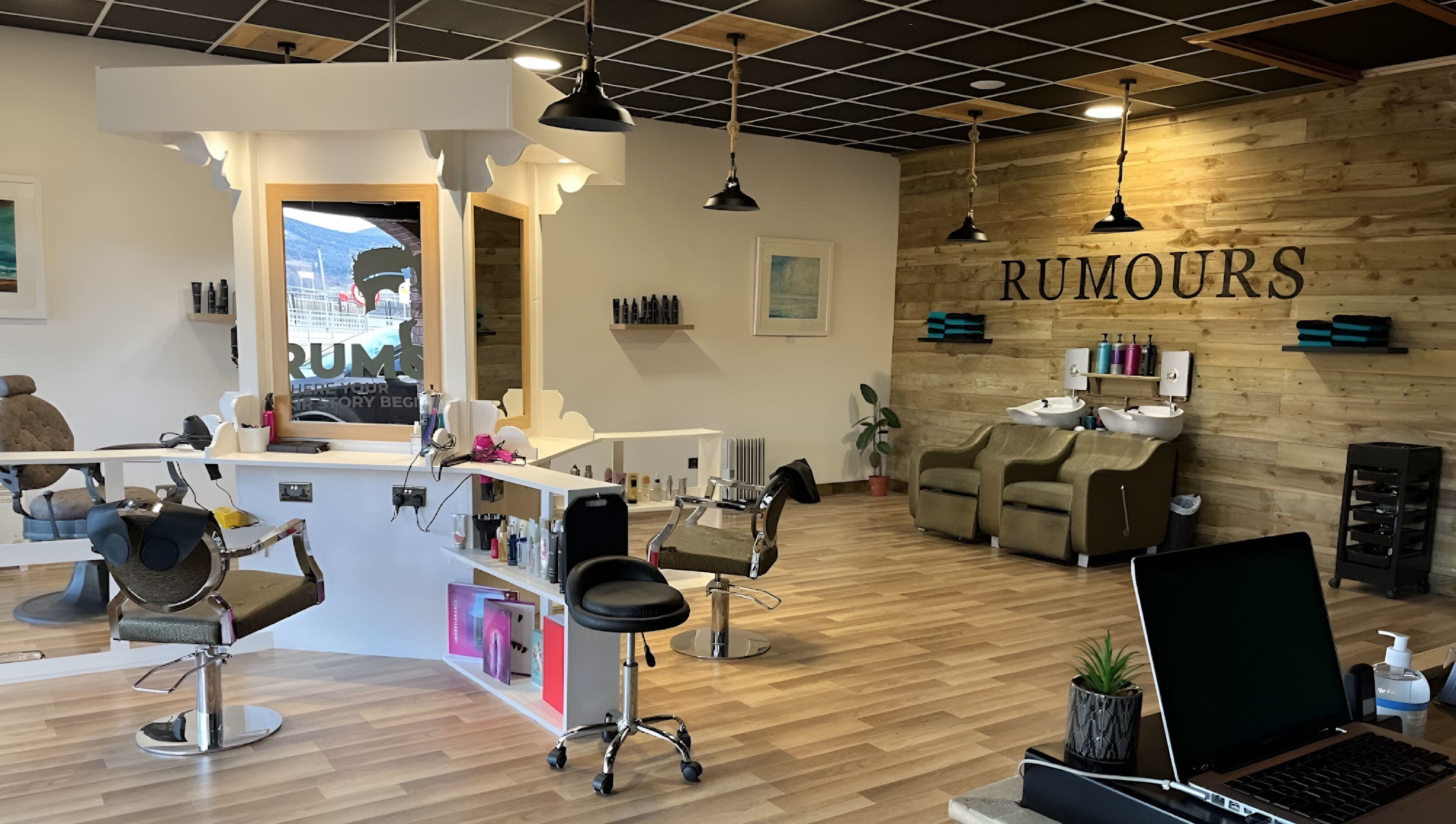 Modern salon interior at Rumours in Brodick, Scotland, GB with elegant wooden decor and styling stations.