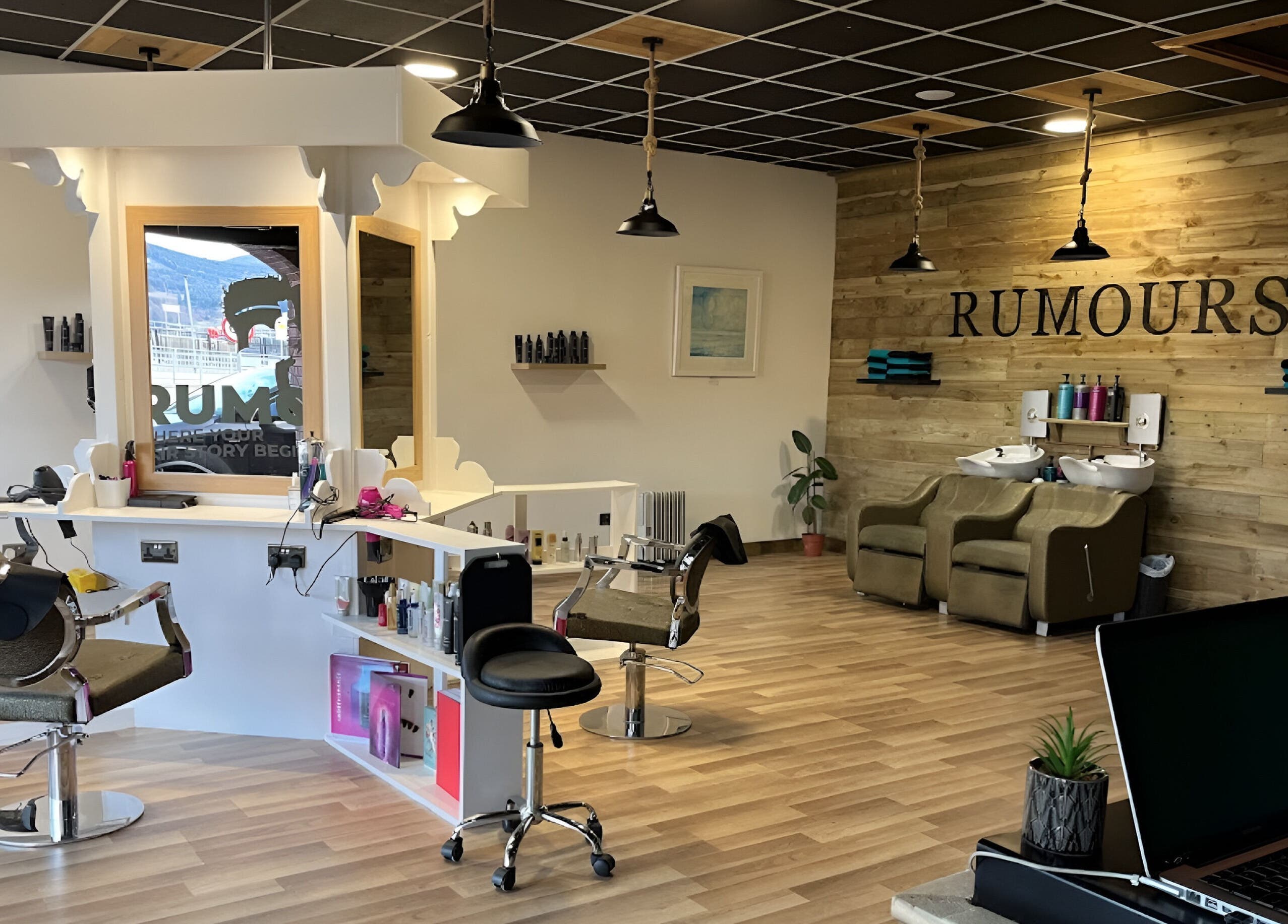 Modern salon interior at Rumours in Brodick, Scotland, GB with elegant wooden decor and styling stations.