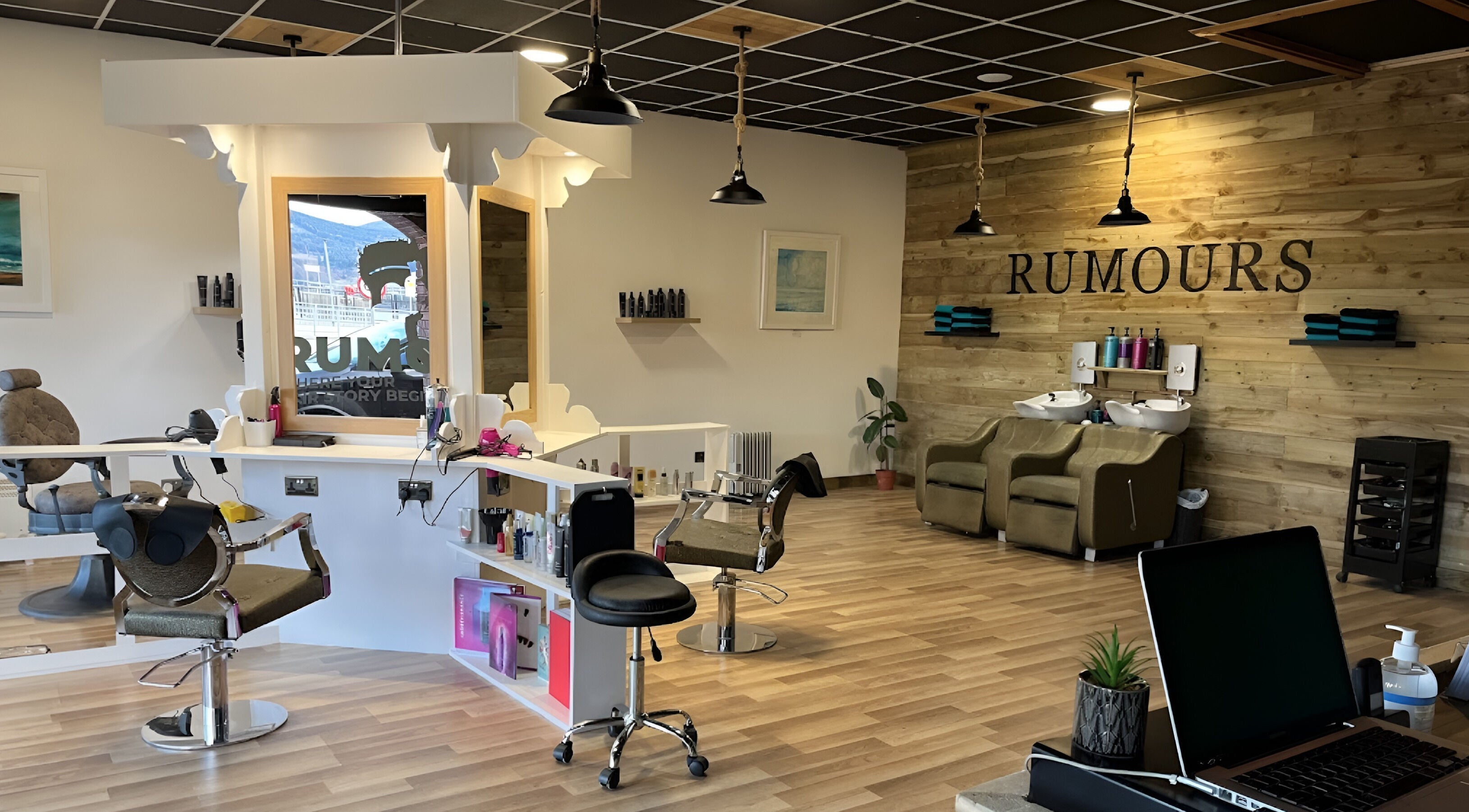 Modern salon interior at Rumours in Brodick, Scotland, GB with elegant wooden decor and styling stations.