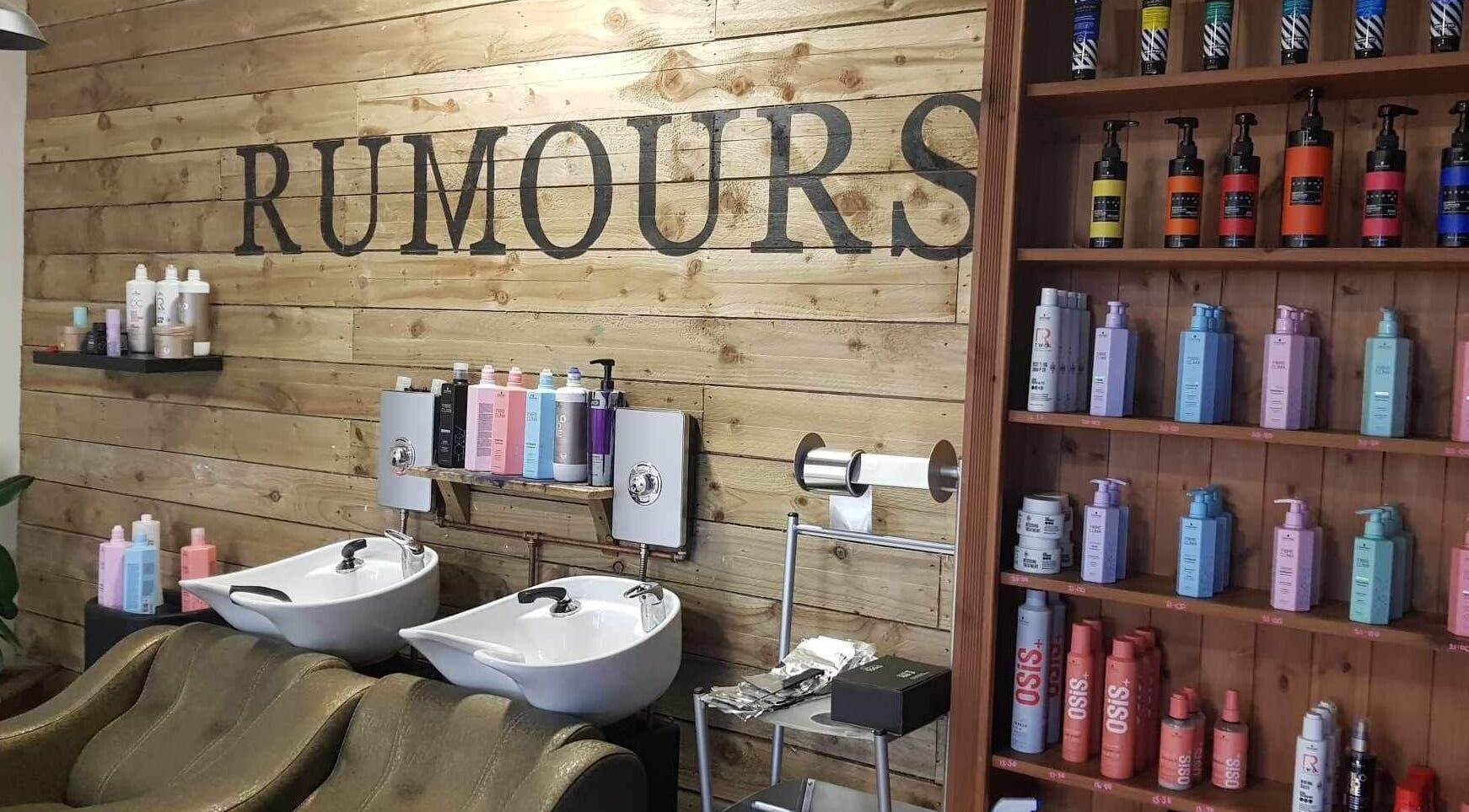 Interior of Rumours, a beauty salon in Brodick, Scotland, GB with wooden walls and colorful products displayed.
