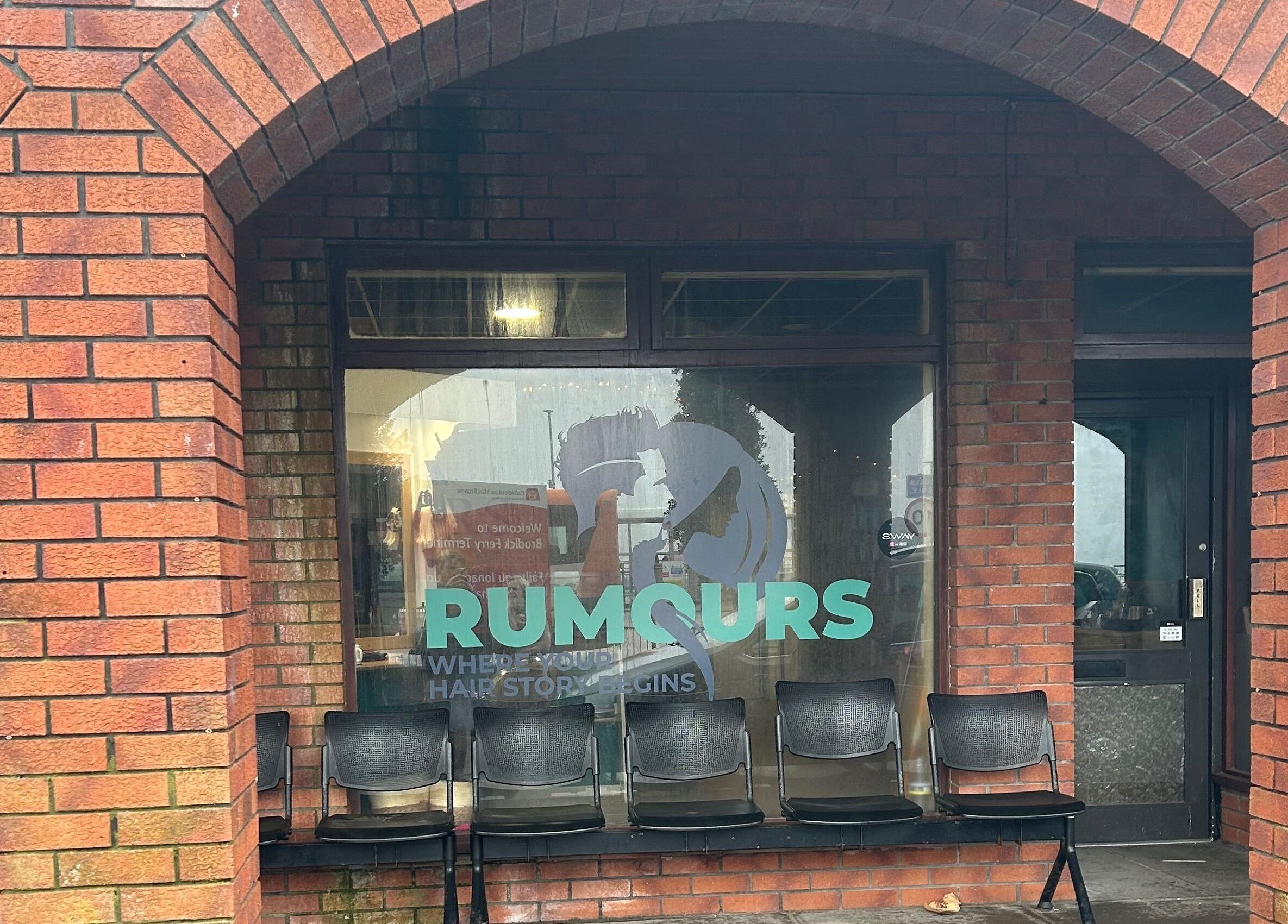Exterior of Rumours salon, Brodick, Scotland, GB, showcasing welcoming seating and stylish signage.