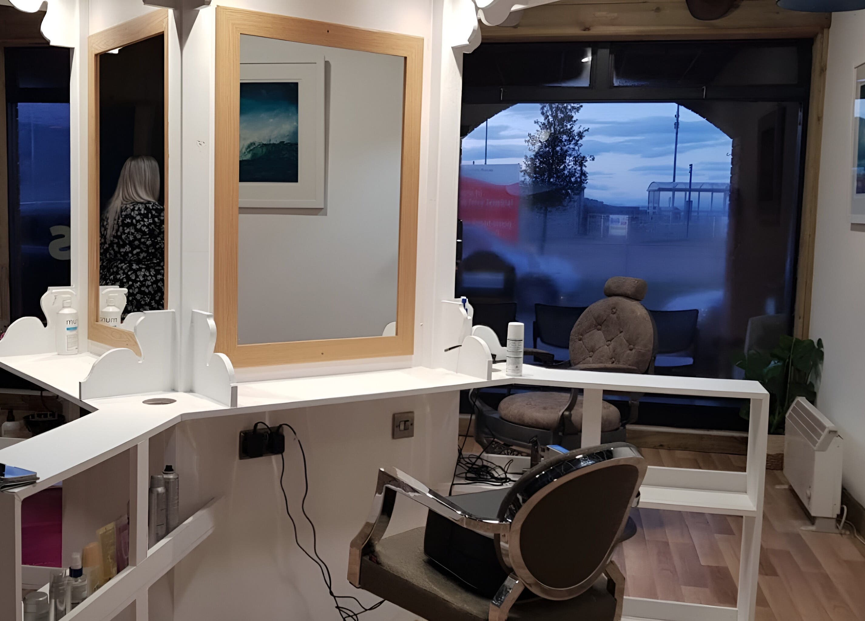 Elegant salon space at Rumours in Brodick, Scotland, GB with stylish mirrors and cozy chairs.