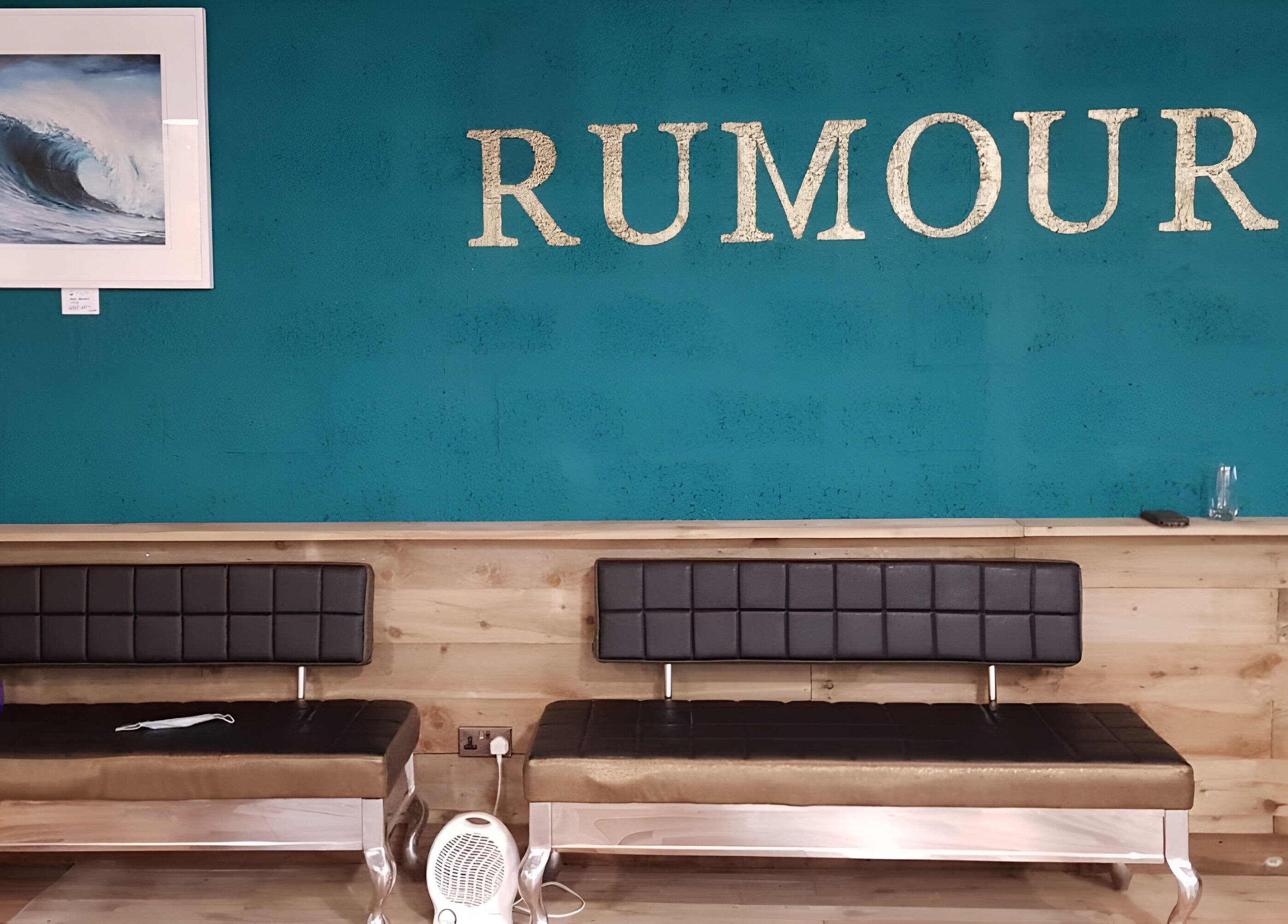 Modern seating area at Rumours, Brodick, Scotland, GB with teal walls and elegant decor.