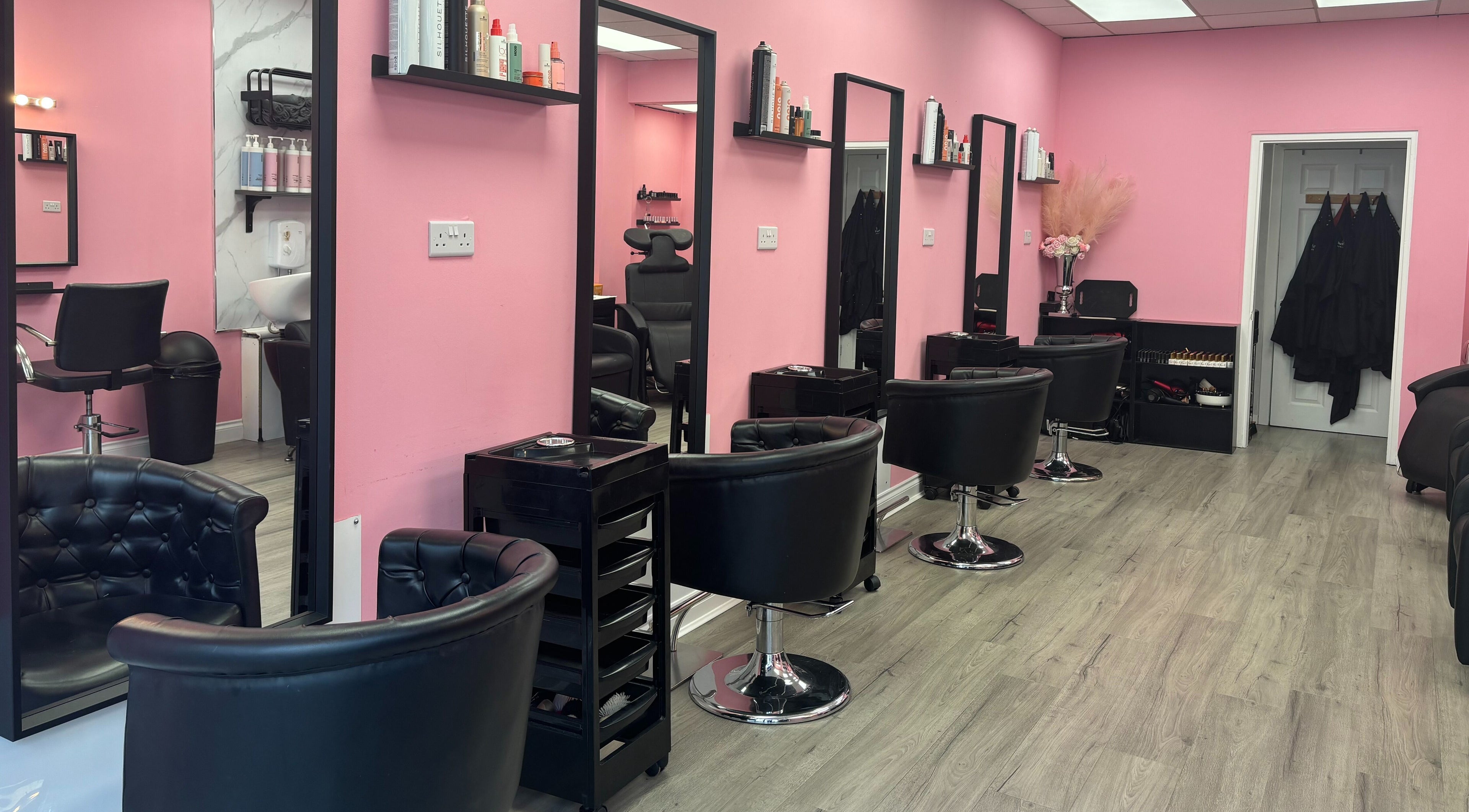 Inside Harley’s Vanity Box Hair & Beauty in Helensburgh, Scotland, GB. Elegant black chairs and pink walls create a stylish ambiance.