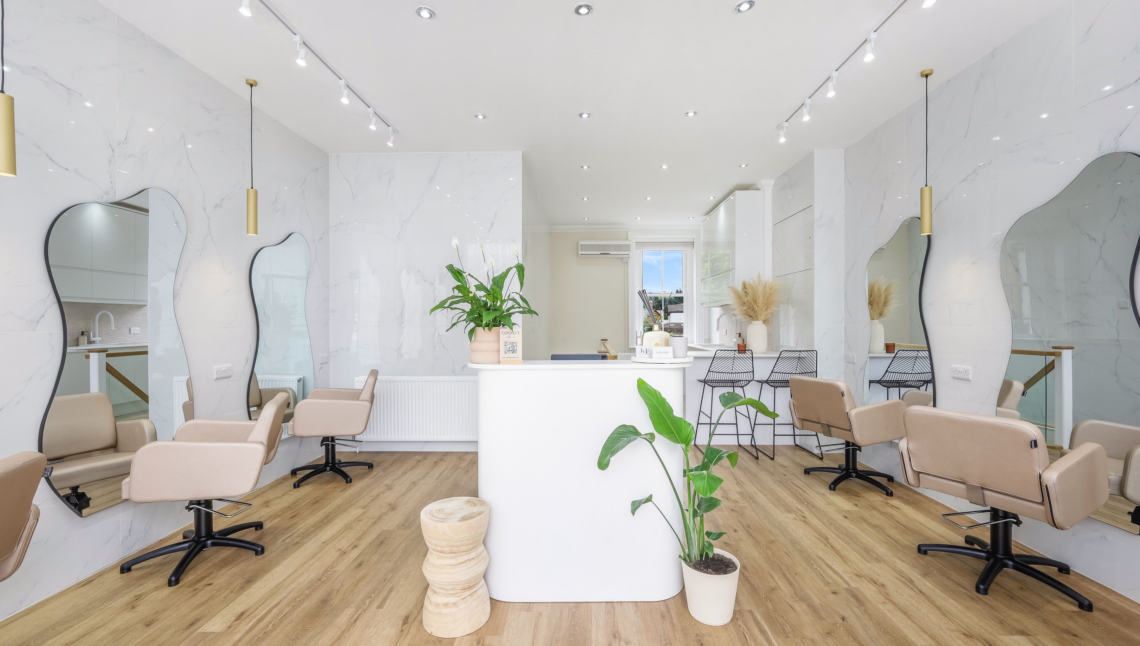 Interior of The Strand Designs salon in Kenley, England, GB, showing elegant chairs and stylish decor.