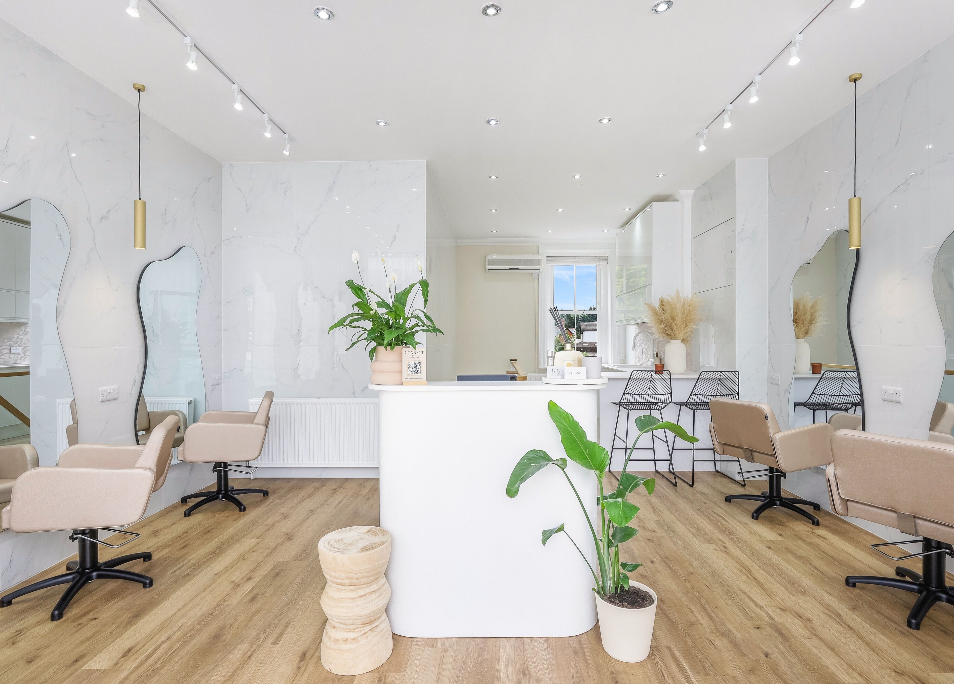 Interior of The Strand Designs salon in Kenley, England, GB, showing elegant chairs and stylish decor.