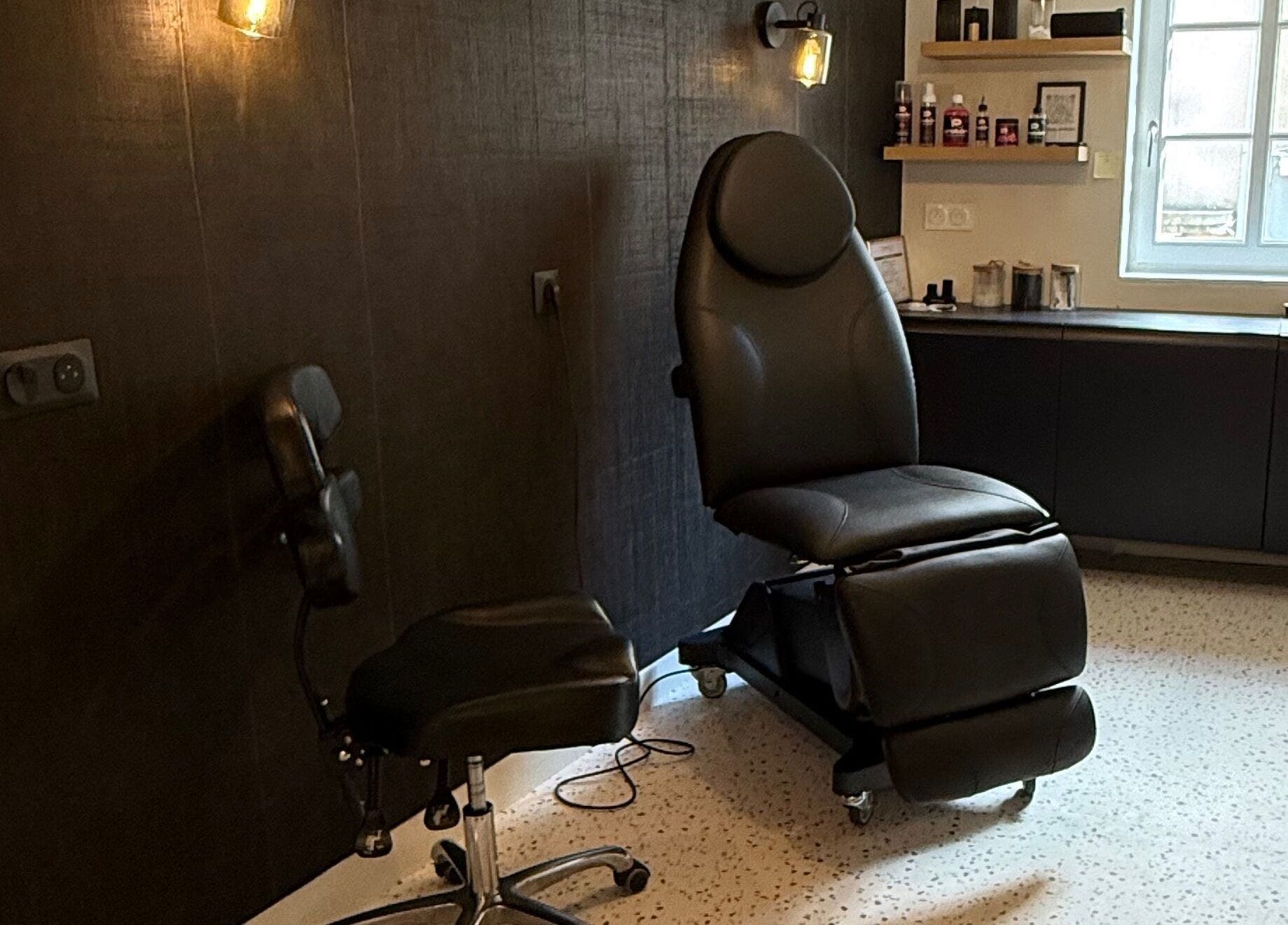 Intérieur élégant de Le rêve d'Aphrodite à Redon, Bretagne, FR, avec chaise de tatouage moderne.