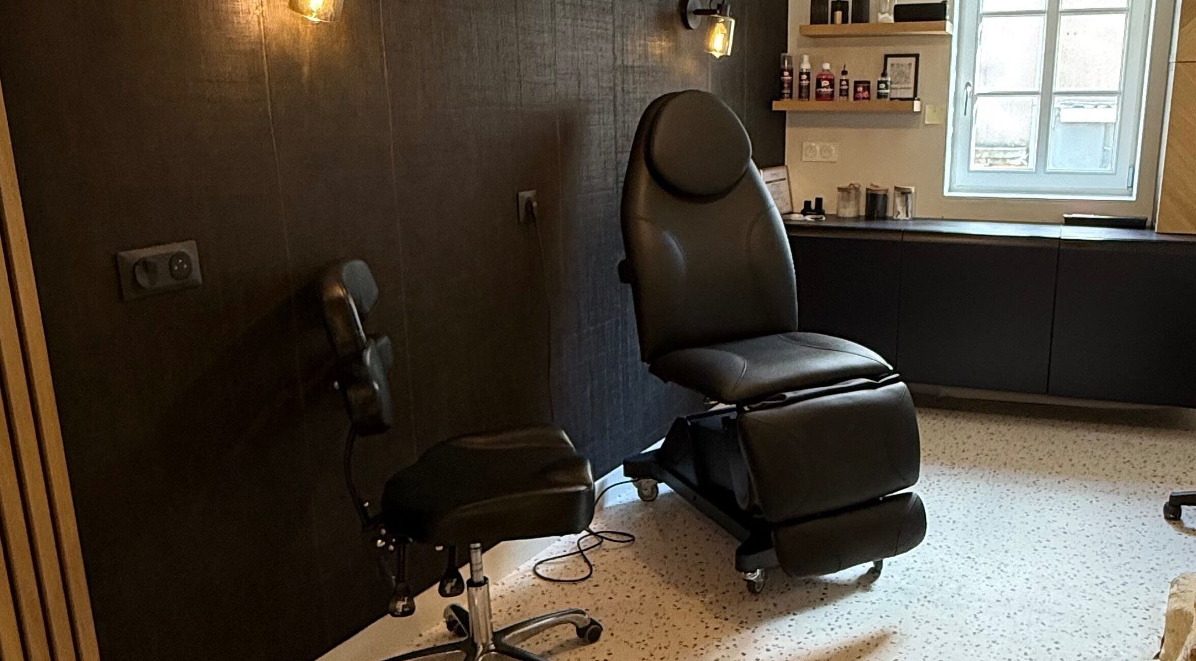 Intérieur élégant de Le rêve d'Aphrodite à Redon, Bretagne, FR, avec chaise de tatouage moderne.