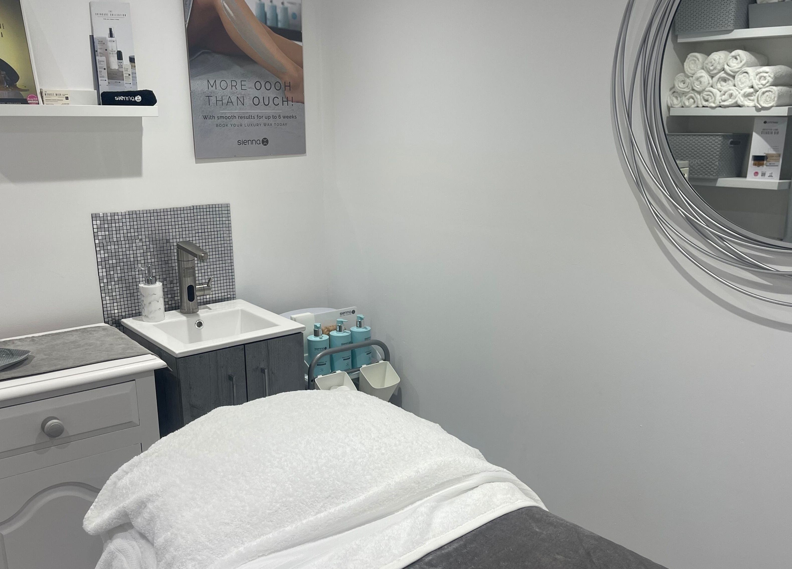 Elegant treatment room at Moore Beauty, Knaphill, England, GB, featuring a plush treatment bed and stylish decor.
