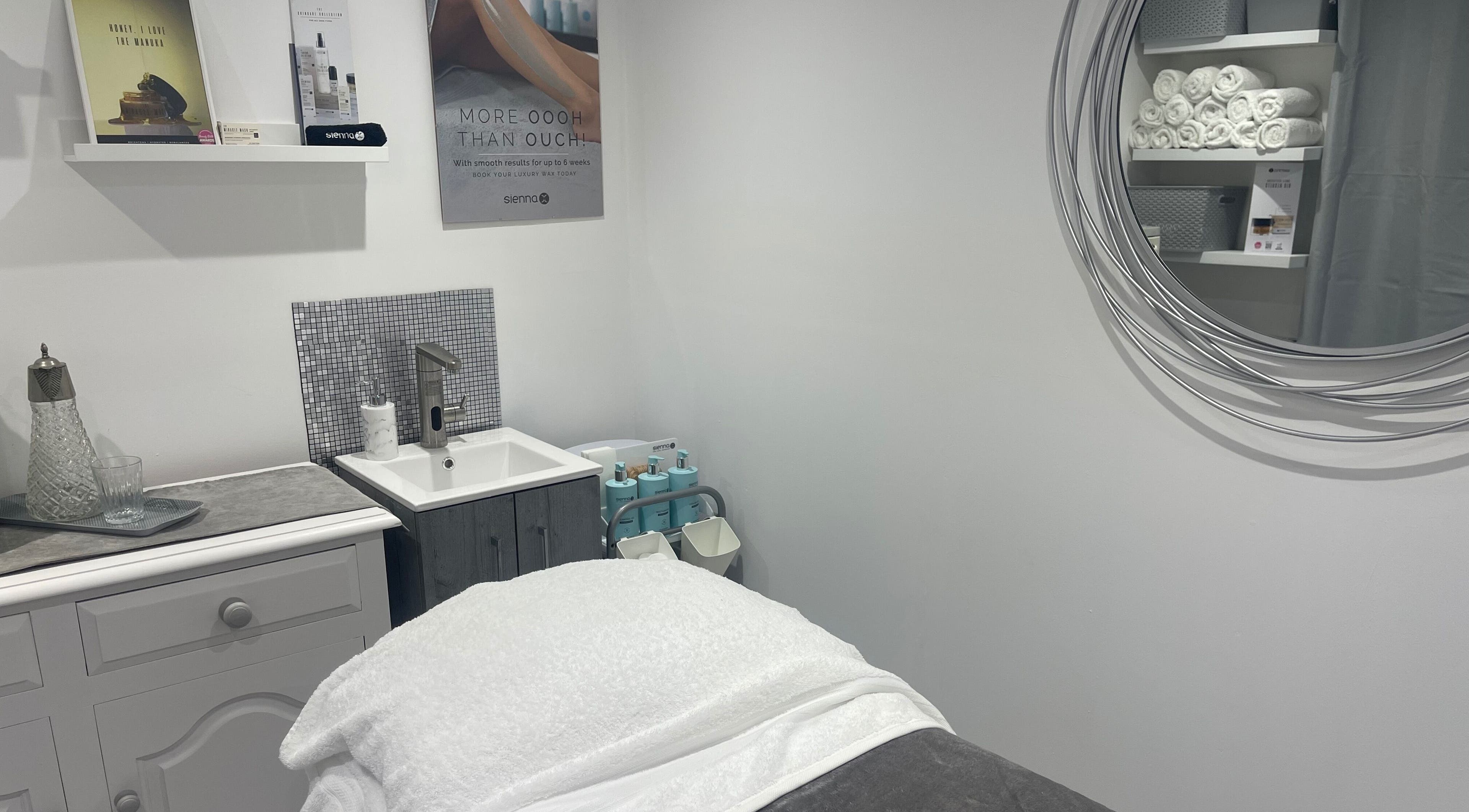 Elegant treatment room at Moore Beauty, Knaphill, England, GB, featuring a plush treatment bed and stylish decor.