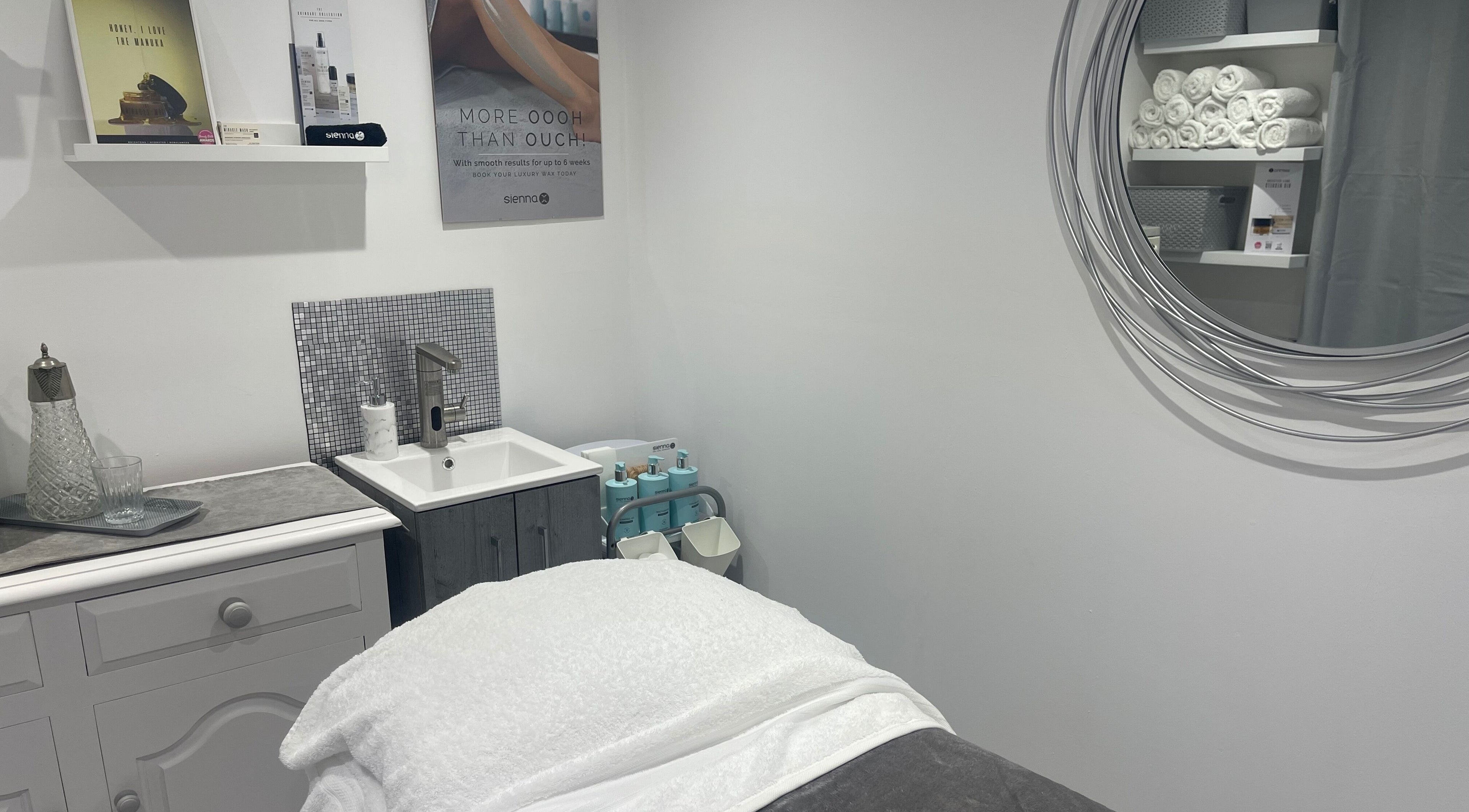 Elegant treatment room at Moore Beauty, Knaphill, England, GB, featuring a plush treatment bed and stylish decor.