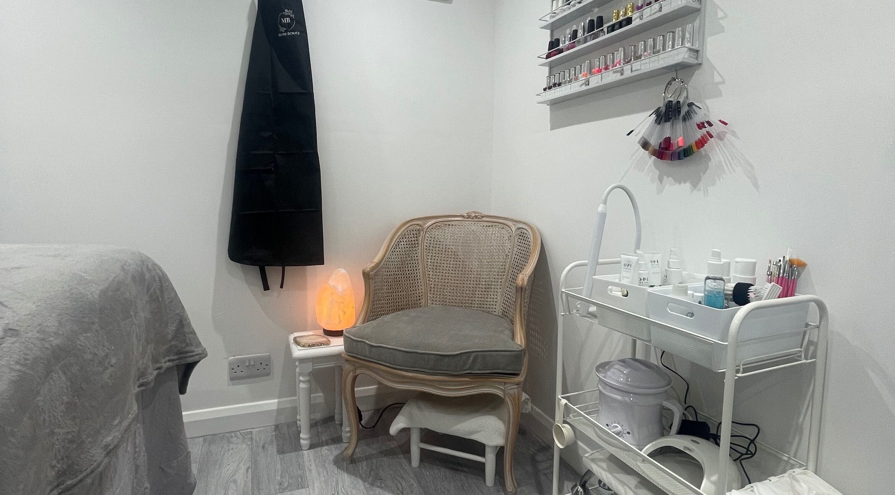 Cozy corner of Moore Beauty in Knaphill, England, featuring a chair, nail polishes, and spa tools.