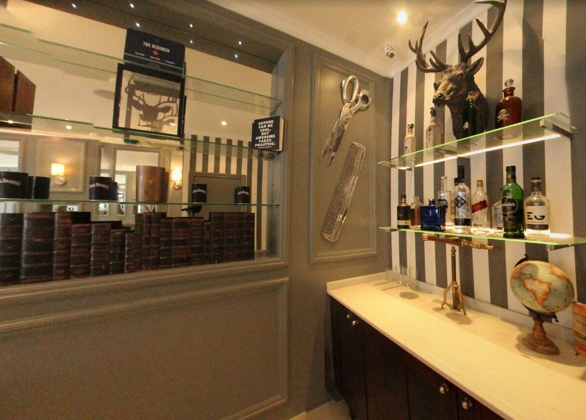 The Stag - Mill Hill in London, England. Elegant interior with a stag head, mirrors, shelves, and bottles.