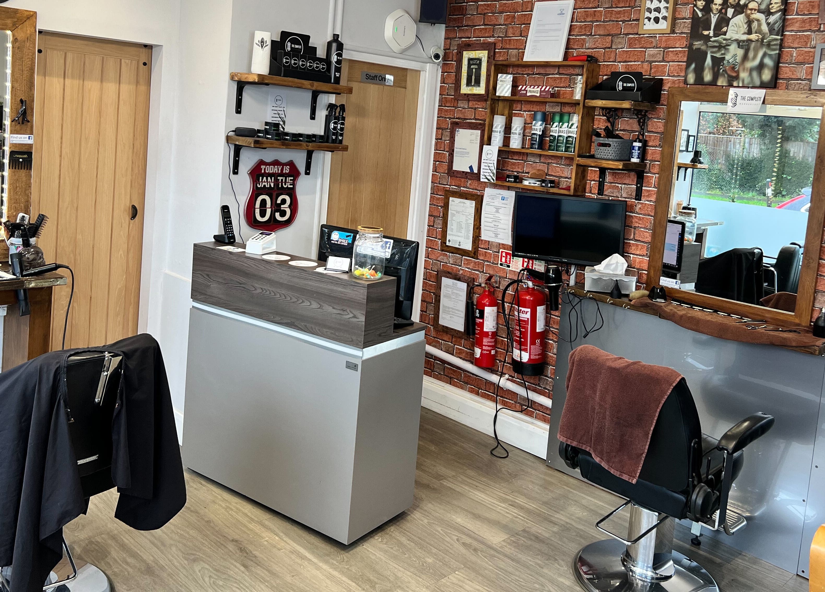 Interior of The Complete Barber Shop Cowfold, Cowfold, England, GB showcasing stylish chairs and grooming tools.