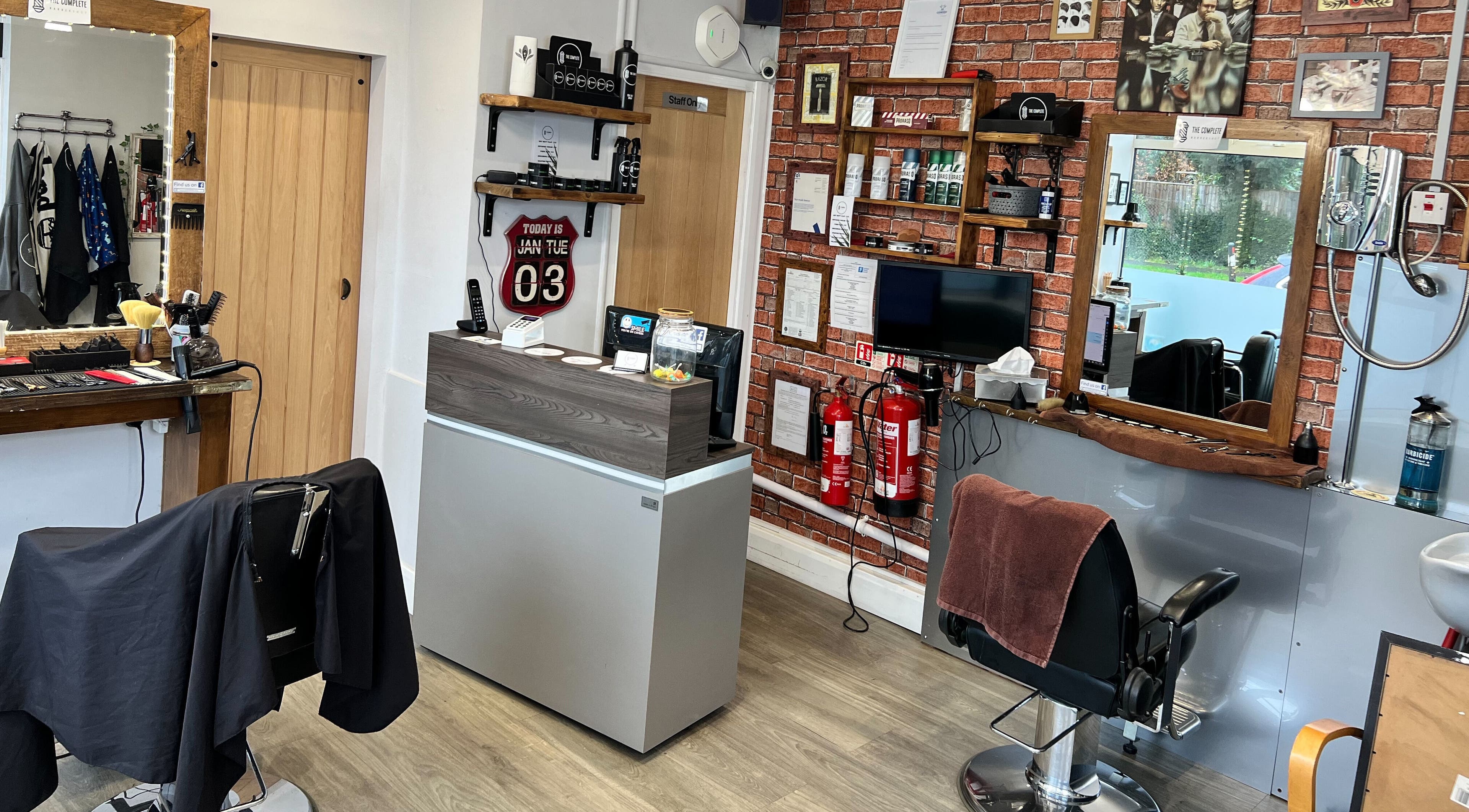 Interior of The Complete Barber Shop Cowfold, Cowfold, England, GB showcasing stylish chairs and grooming tools.