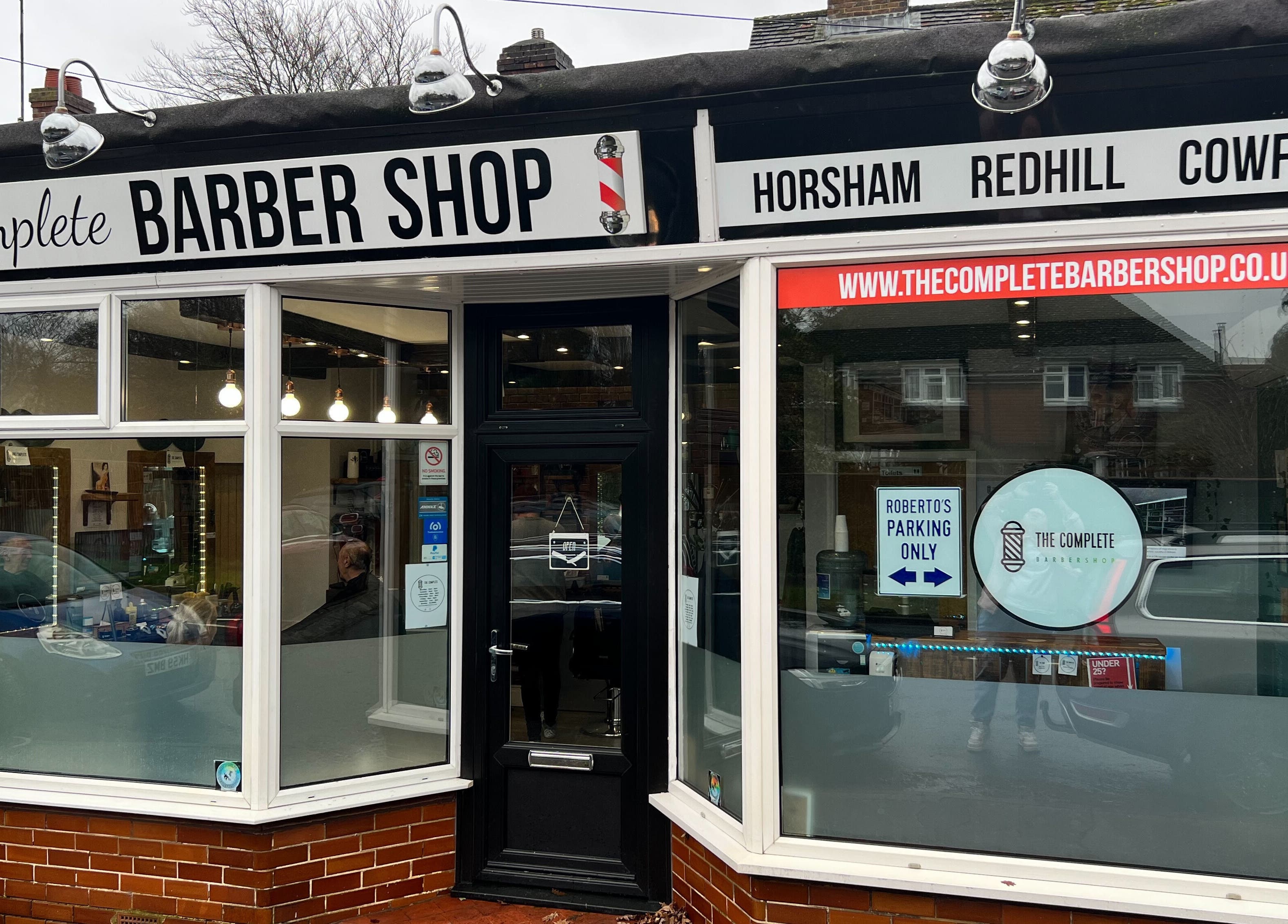 The Complete Barber Shop Cowfold exterior with large windows in Cowfold, England, GB.