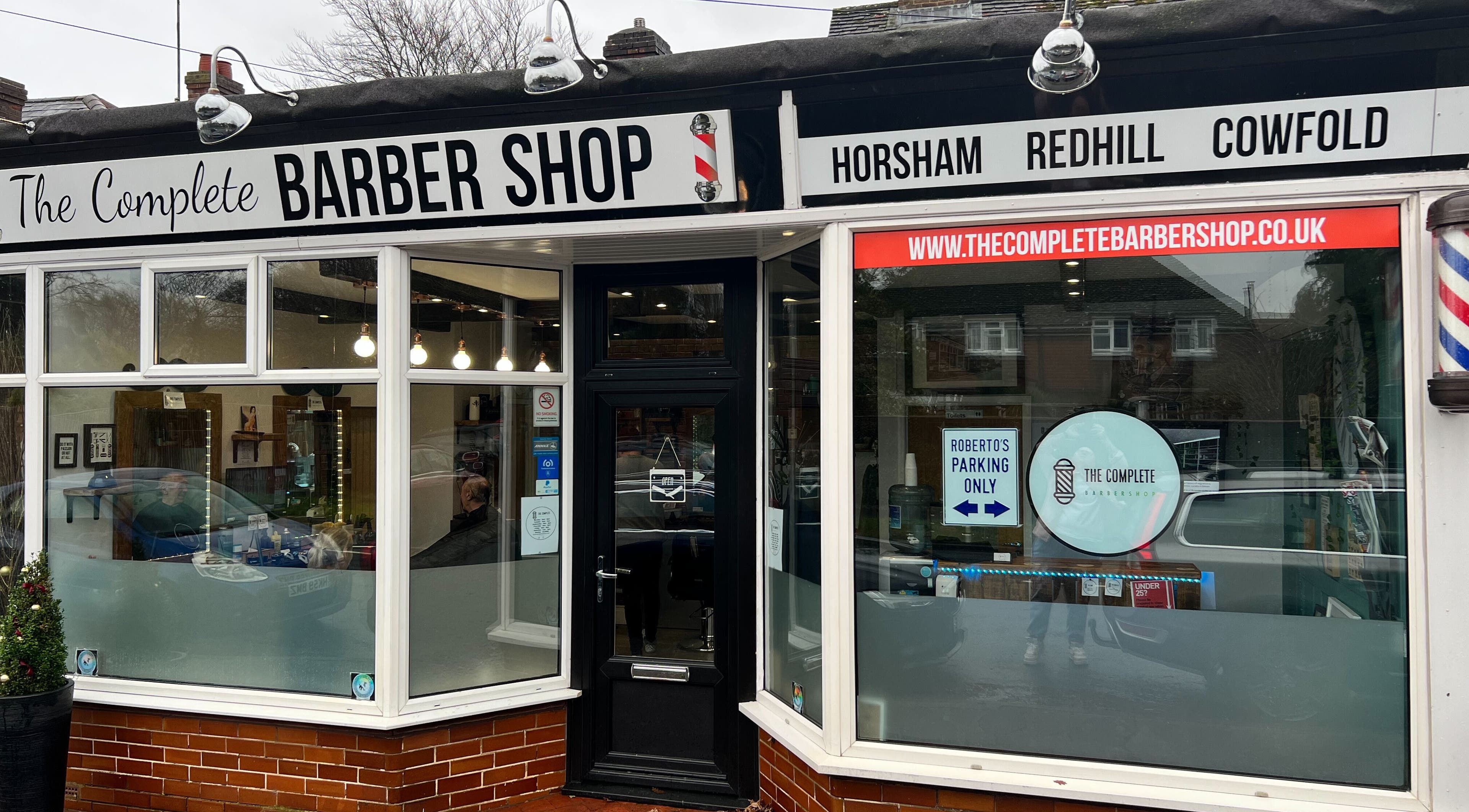 The Complete Barber Shop Cowfold exterior with large windows in Cowfold, England, GB.