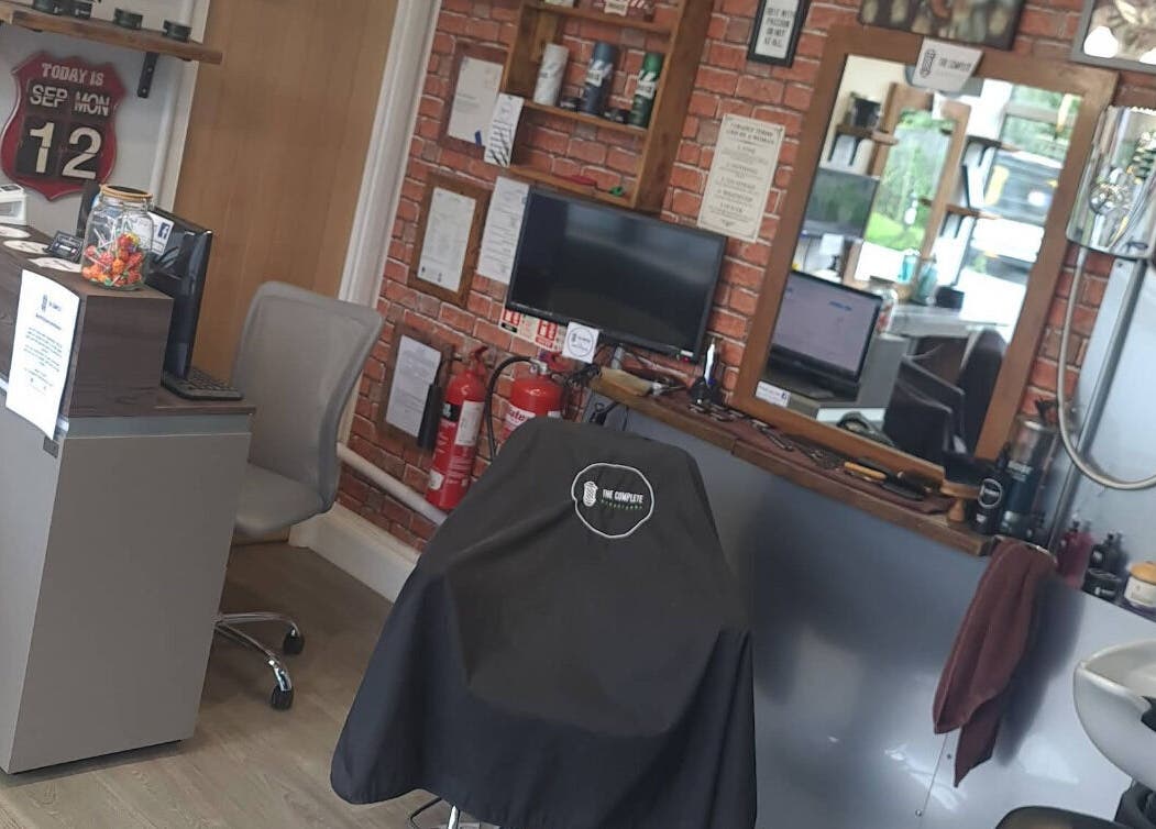 Interior of The Complete Barber Shop Cowfold in Cowfold, England, GB, featuring styling stations and barber chair.