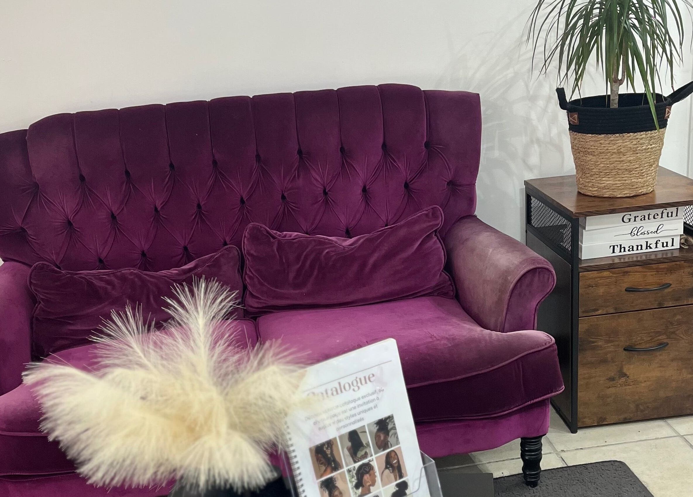 Canapé en velours rouge chez Tika Braids, Elbeuf, Normandie, FR, offrant une ambiance confortable et élégante.