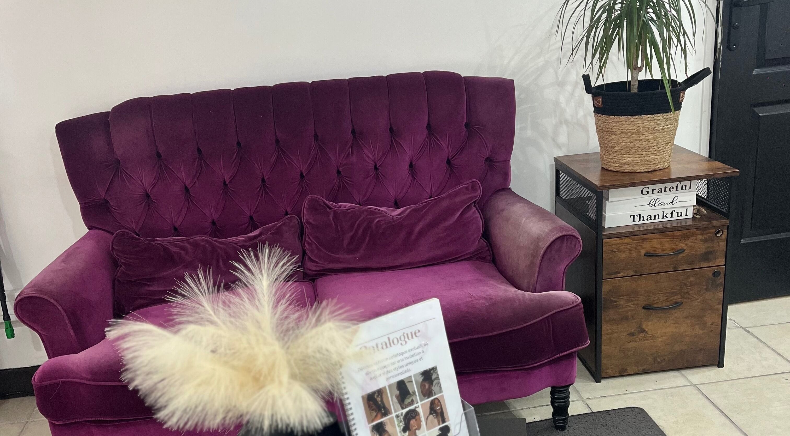 Canapé en velours rouge chez Tika Braids, Elbeuf, Normandie, FR, offrant une ambiance confortable et élégante.