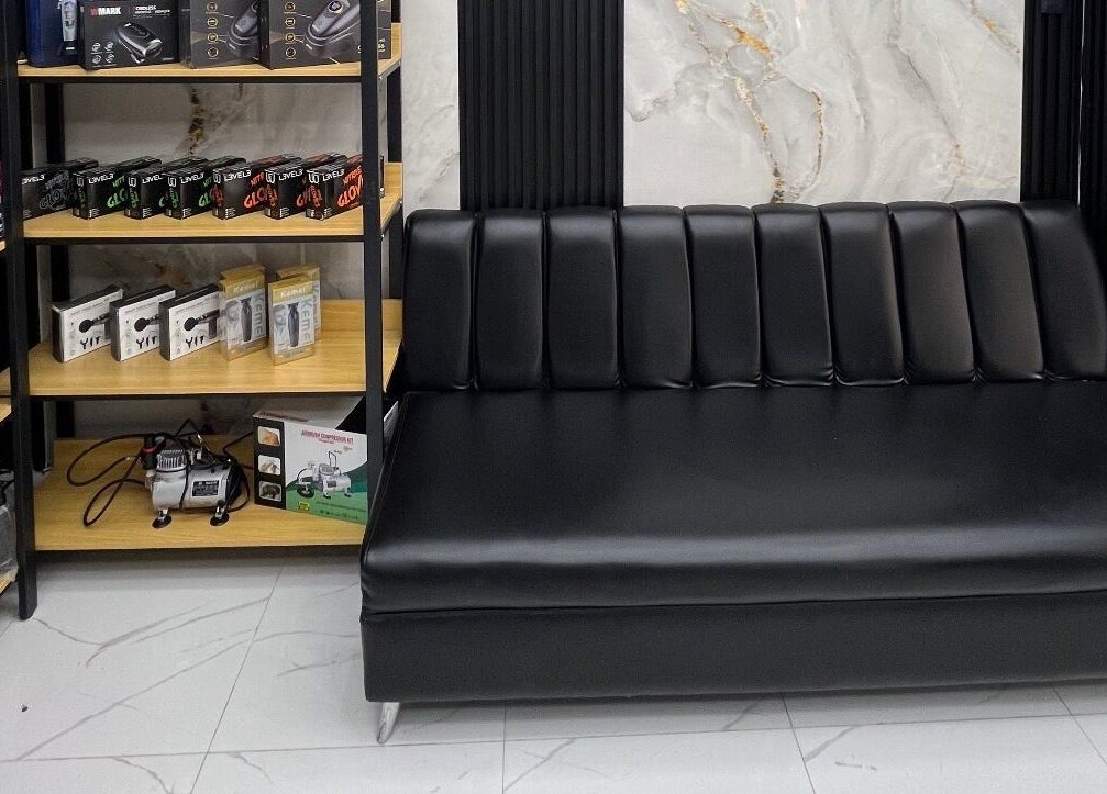Sofá negro de diseño elegante en GECS BARBER STUDIO en Santo Domingo, DO, ideal para clientes.