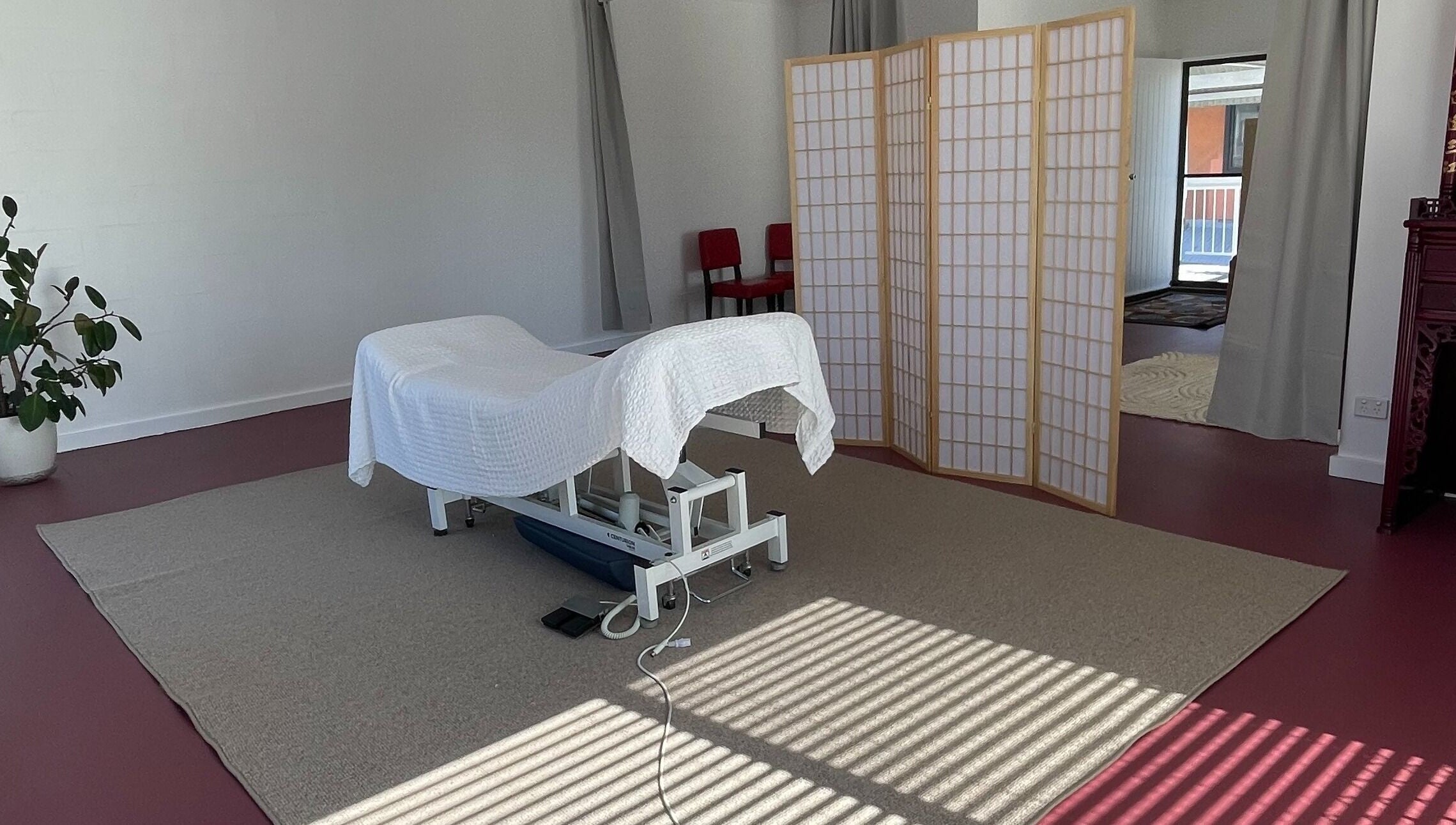 Tranquil massage room at The Biofield Body - Byron Bay, New South Wales, AU, with a white treatment bed.