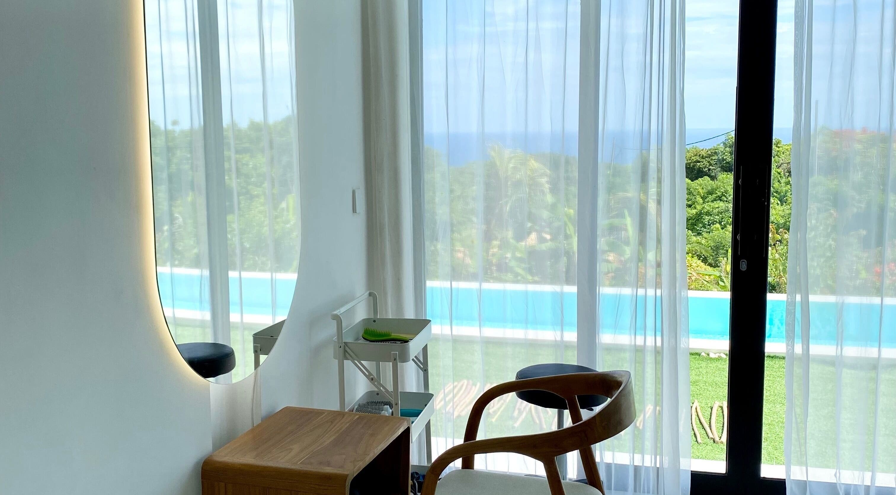 Relaxing corner with ocean view at Mila Hair Spa, Bali, Bali, ID. Elegant chair and mirror setup.