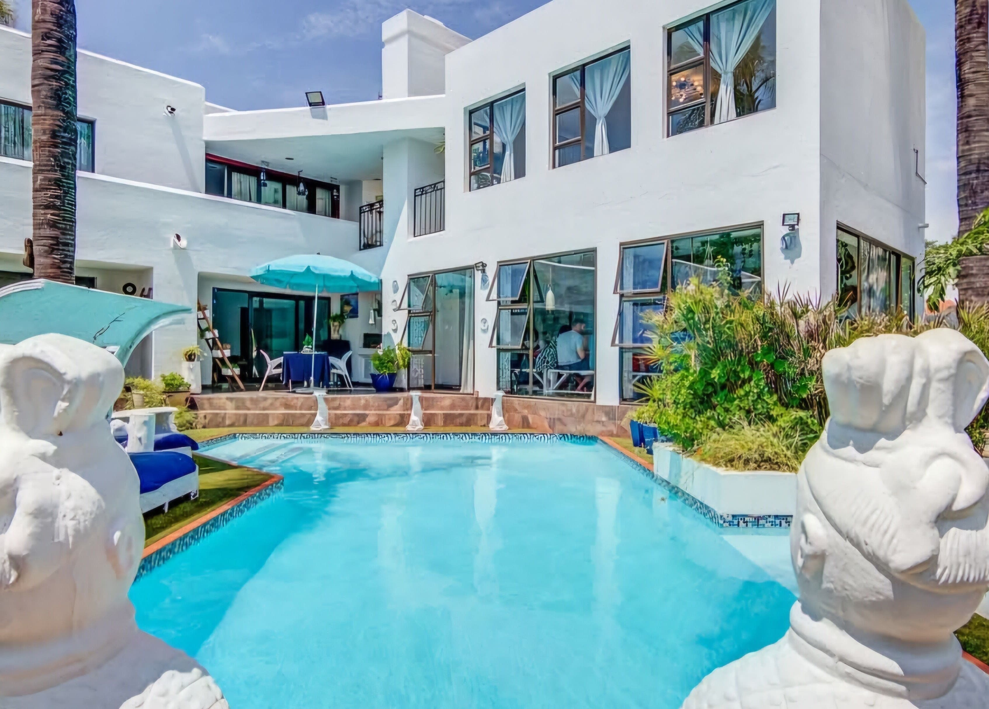 Relax by the poolside oasis at Hair On View in Boksburg, Gauteng, ZA, featuring serene white architecture.