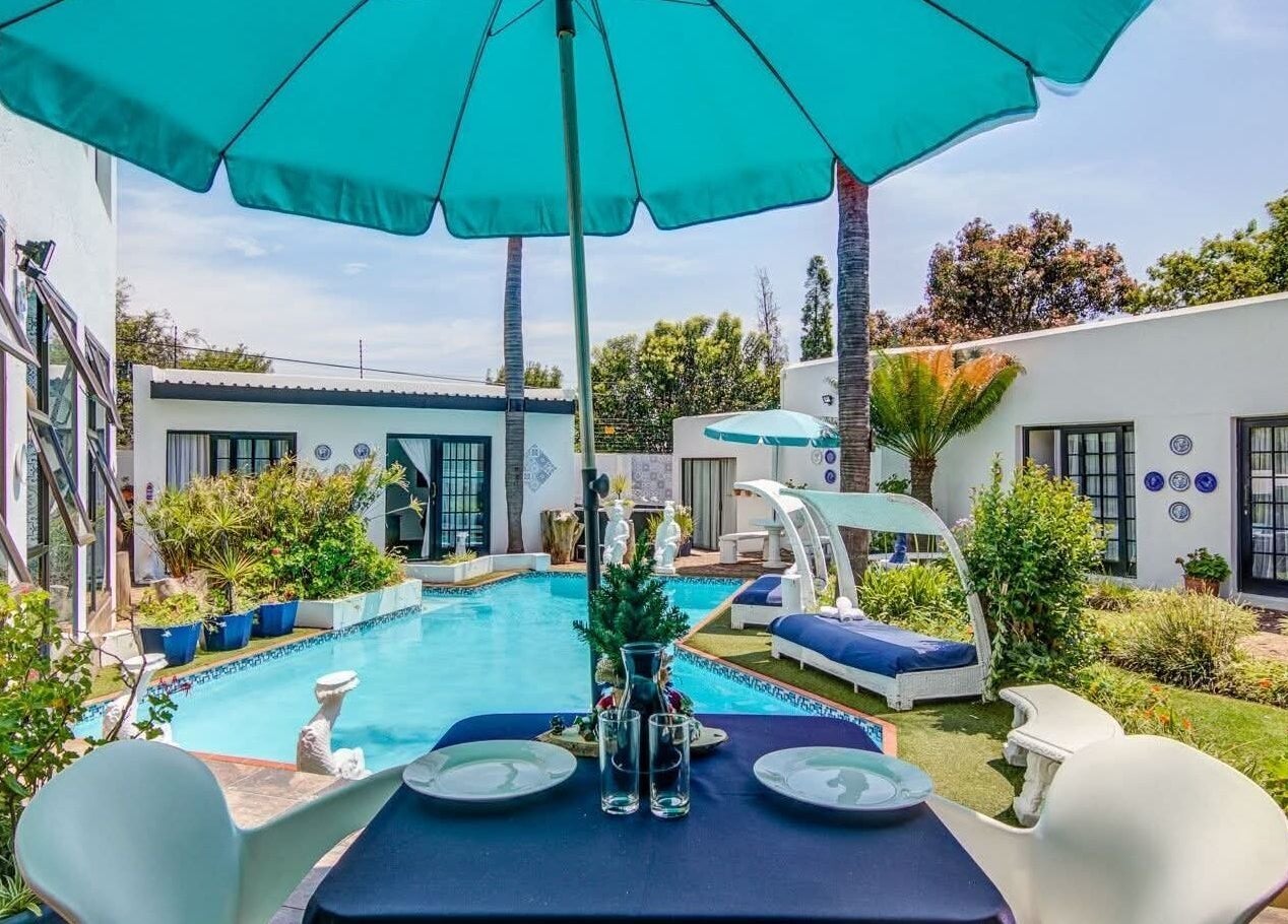 Relaxing poolside view at Hair On View, Boksburg, Gauteng, ZA. Lush gardens and lounging chairs create a serene retreat.
