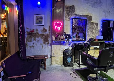 Goblings barbershop in Melaka features a vibrant neon-lit interior with modern barber chairs.