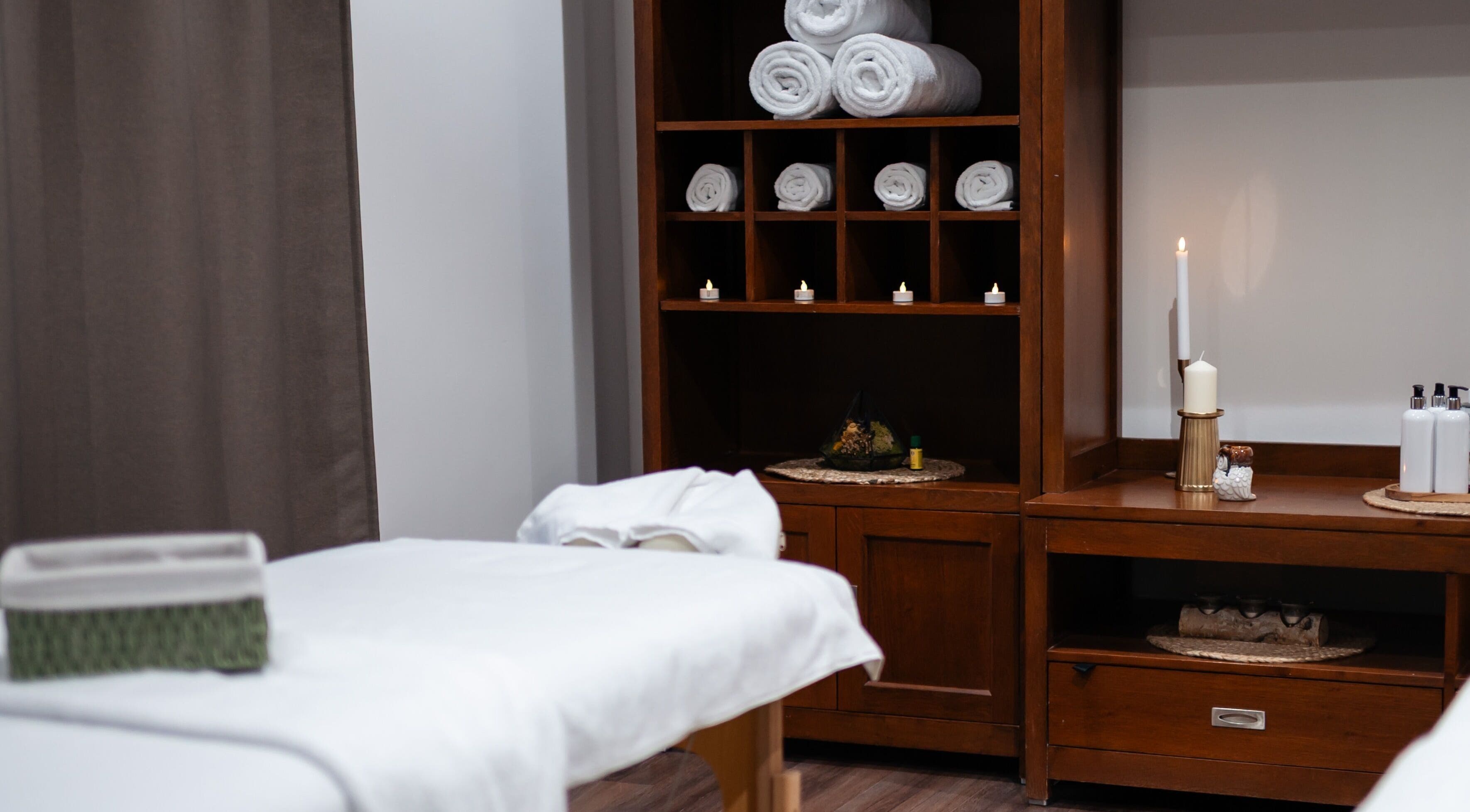 Camera de tratament elegantă la Harmony Wellness Cotroceni, București, București, RO, cu prosoape și lumânări.