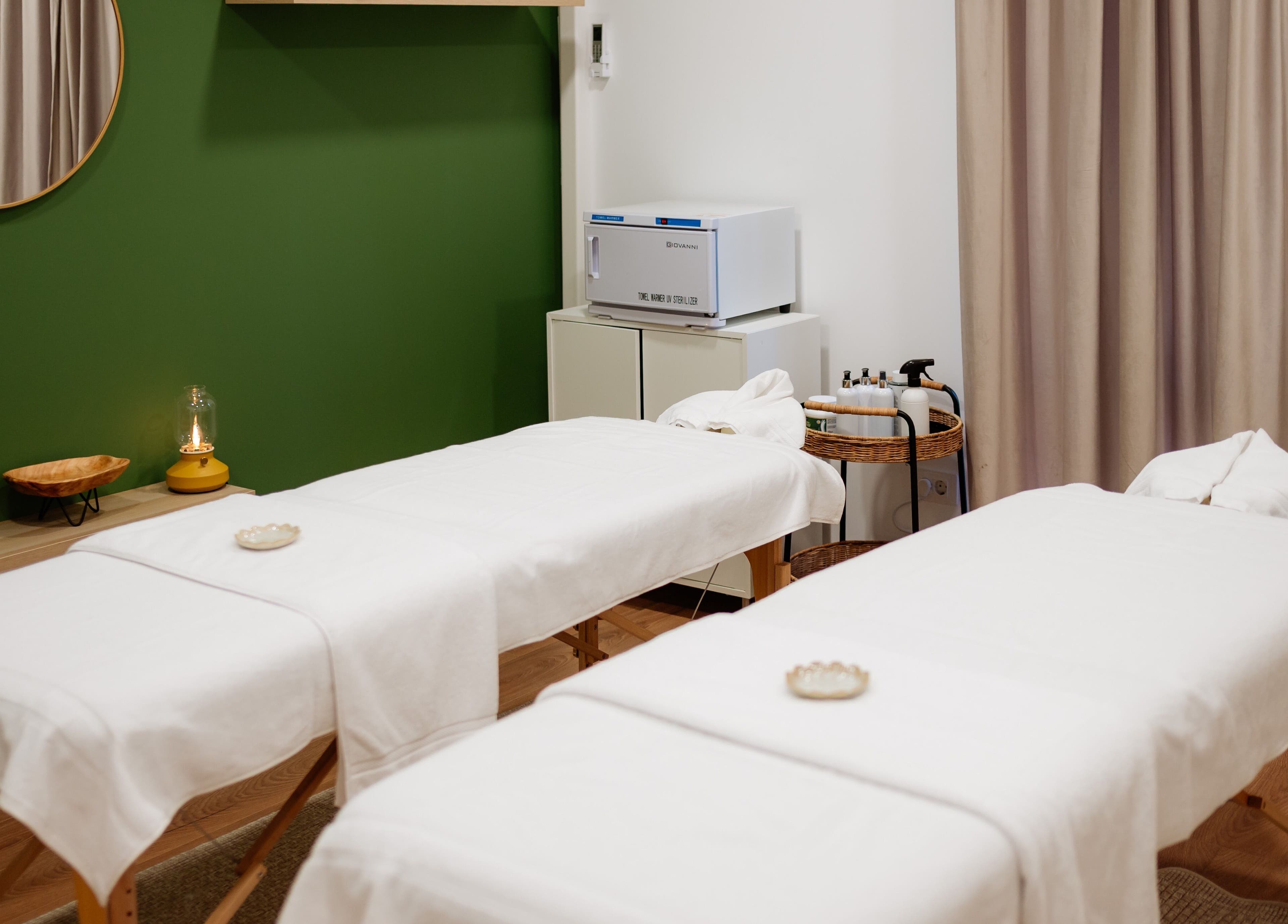 Sala de masaj la Harmony Wellness Cotroceni, București, București, RO, cu paturi albe și decor elegant.