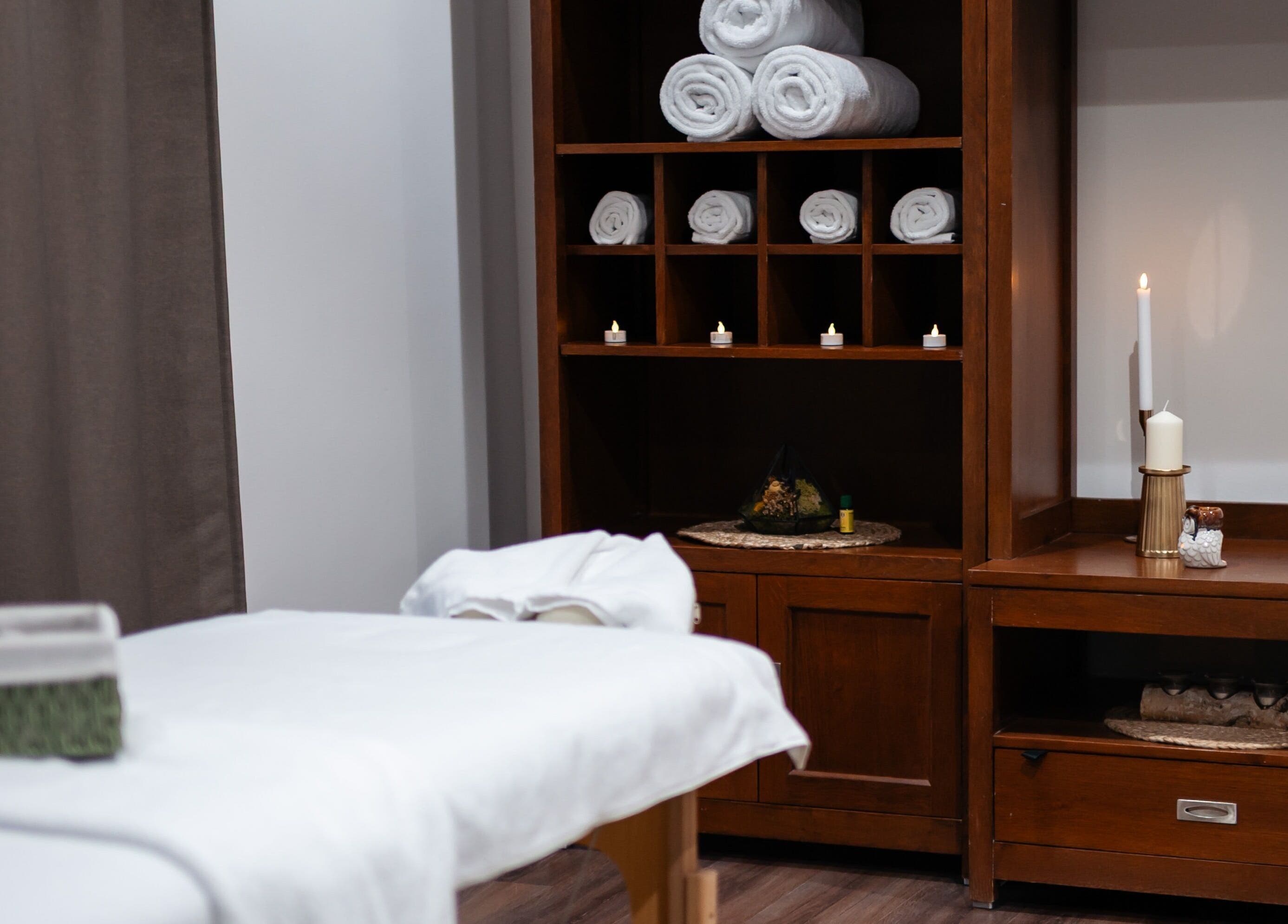 Cameră de masaj la Harmony Wellness Cotroceni, București, RO, cu șervețele albe și lumânări.