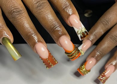 Intricate nail art design at CZR Nails, London, England, GB featuring gold embellishments and vibrant colors.