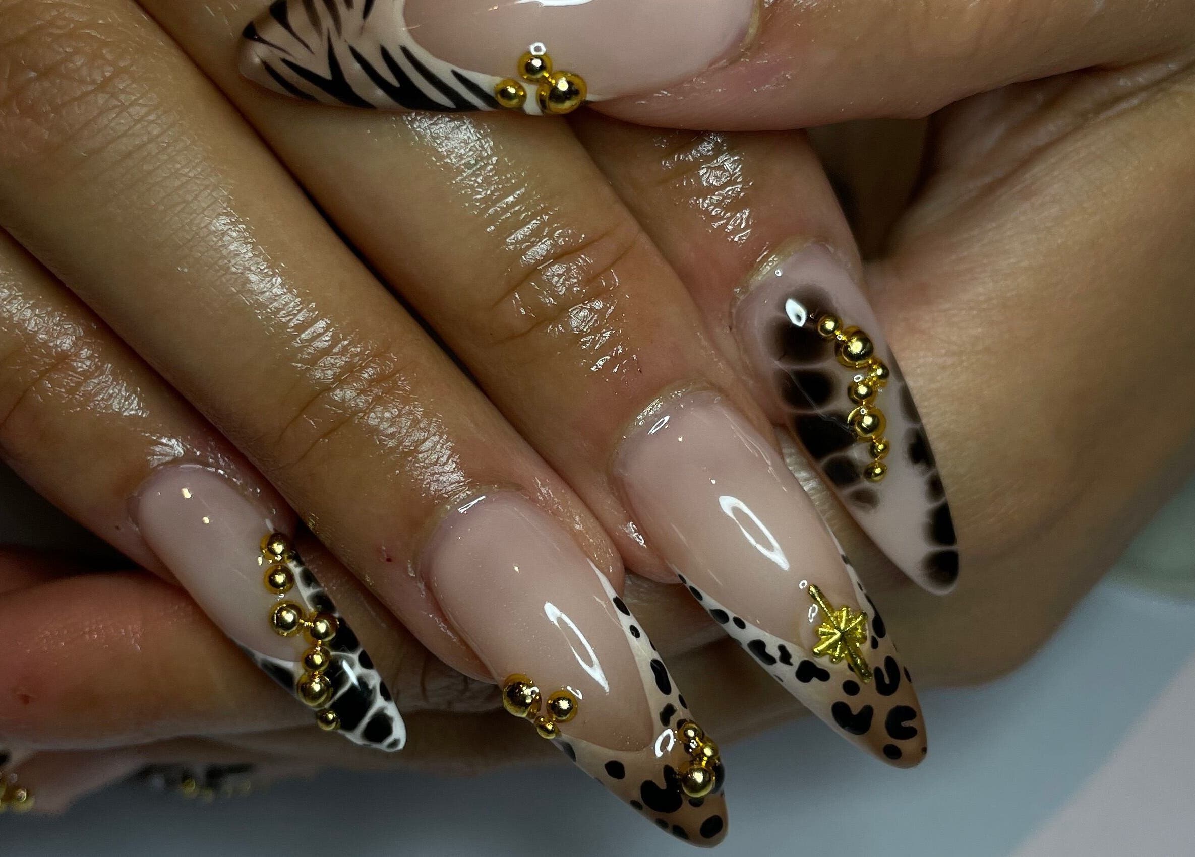 Intricate animal print nails with gold accents at CZR Nails in London, England, GB.
