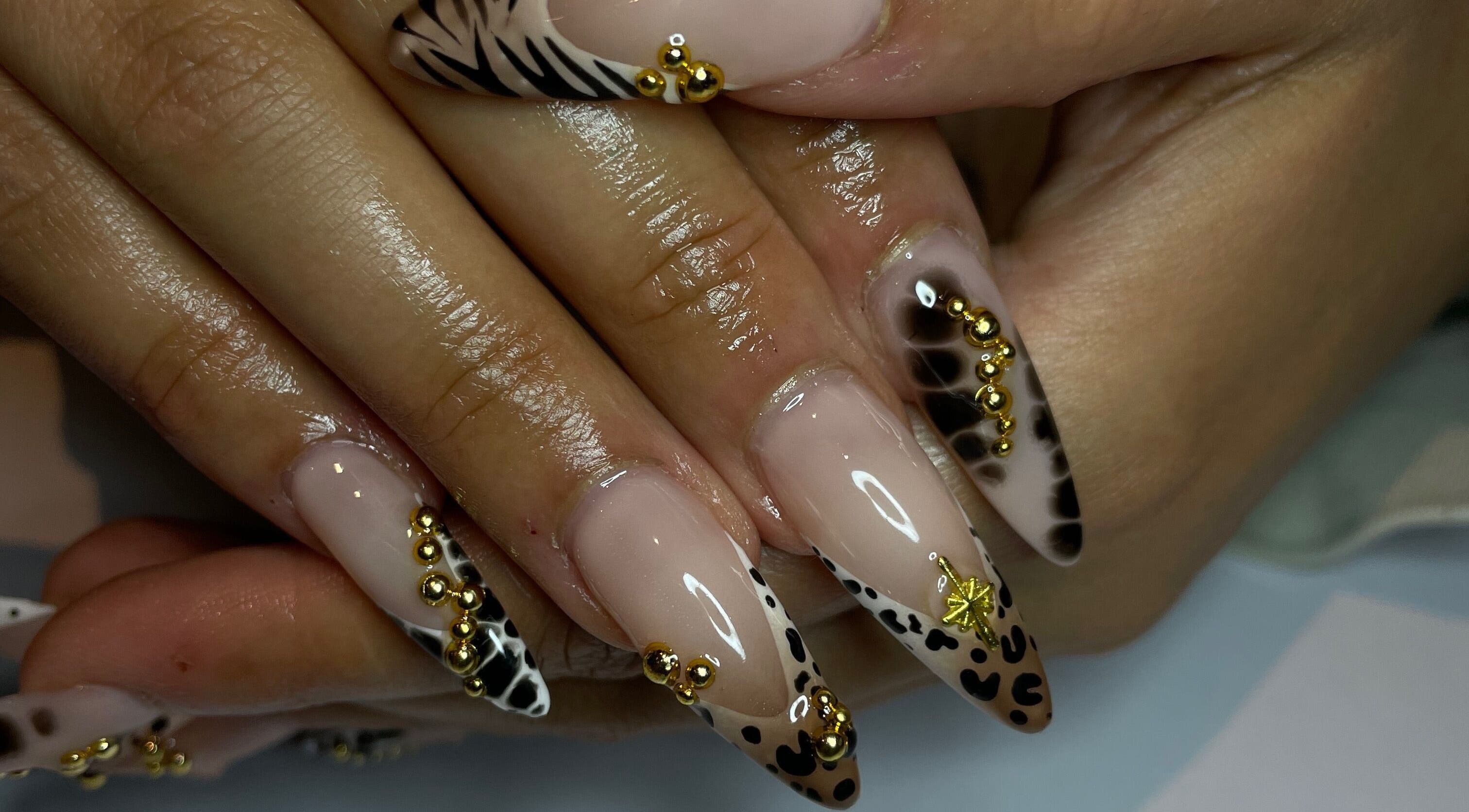 Intricate animal print nails with gold accents at CZR Nails in London, England, GB.
